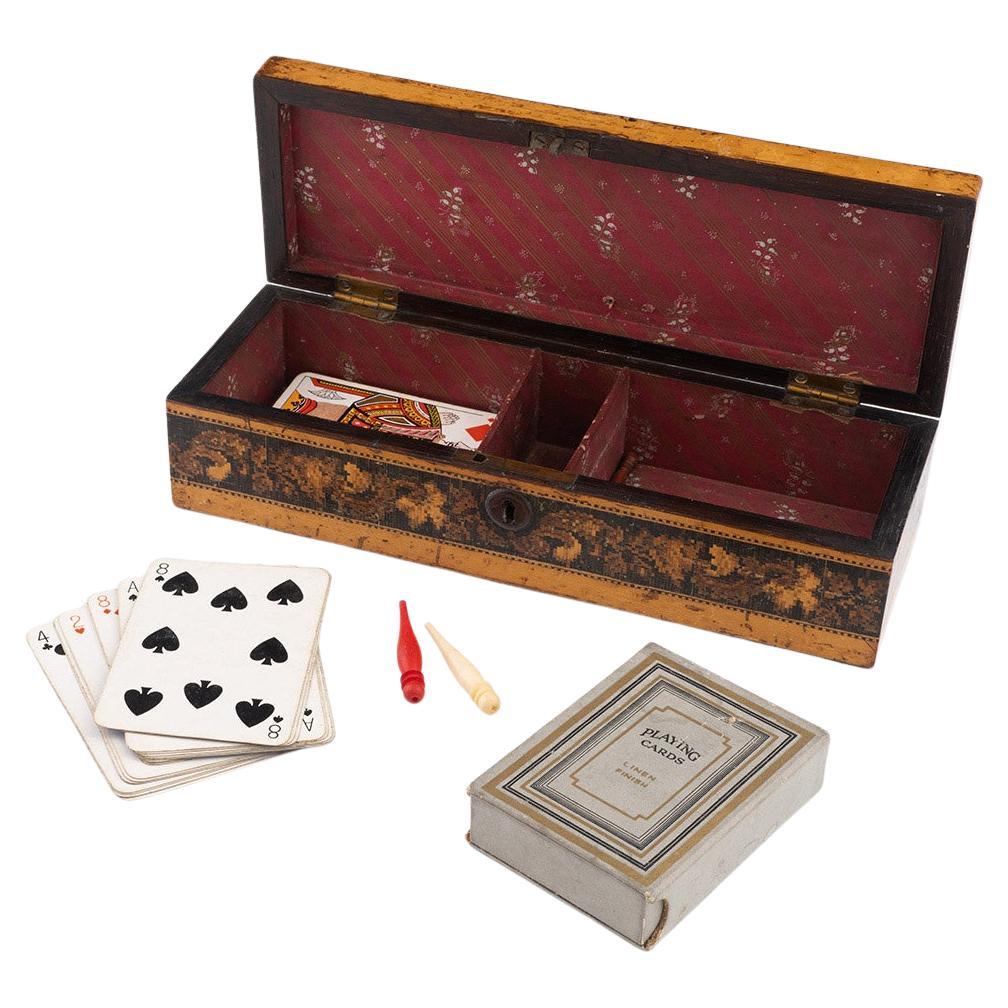 Heading : Tunbridge ware games box with cribbage board by Childs and Son

Date : c1860

Period : Victoria

Origin : Brighton, East Sussex

Decoration : Central scrolled acanthus leaf mosaic with cribbage board around the outside and geometric