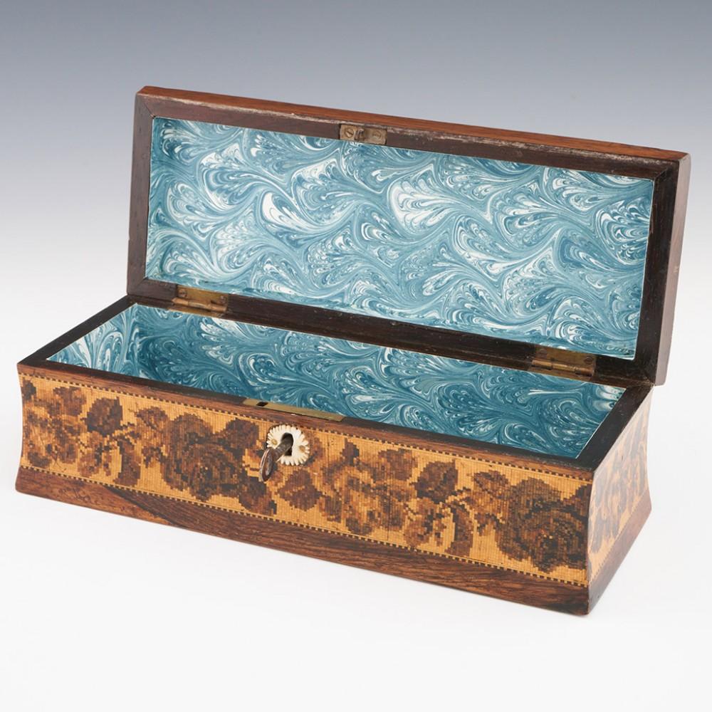 Heading : Tunbridge ware glove box with image of Tonbridge Castle
Date : c1860
Period : Victoria
Origin : Tunbridge Wells, Kent
Decoration : Central mosaic of Tonbirdge castle within a geometric border with keylines. Side panels decorated with rose