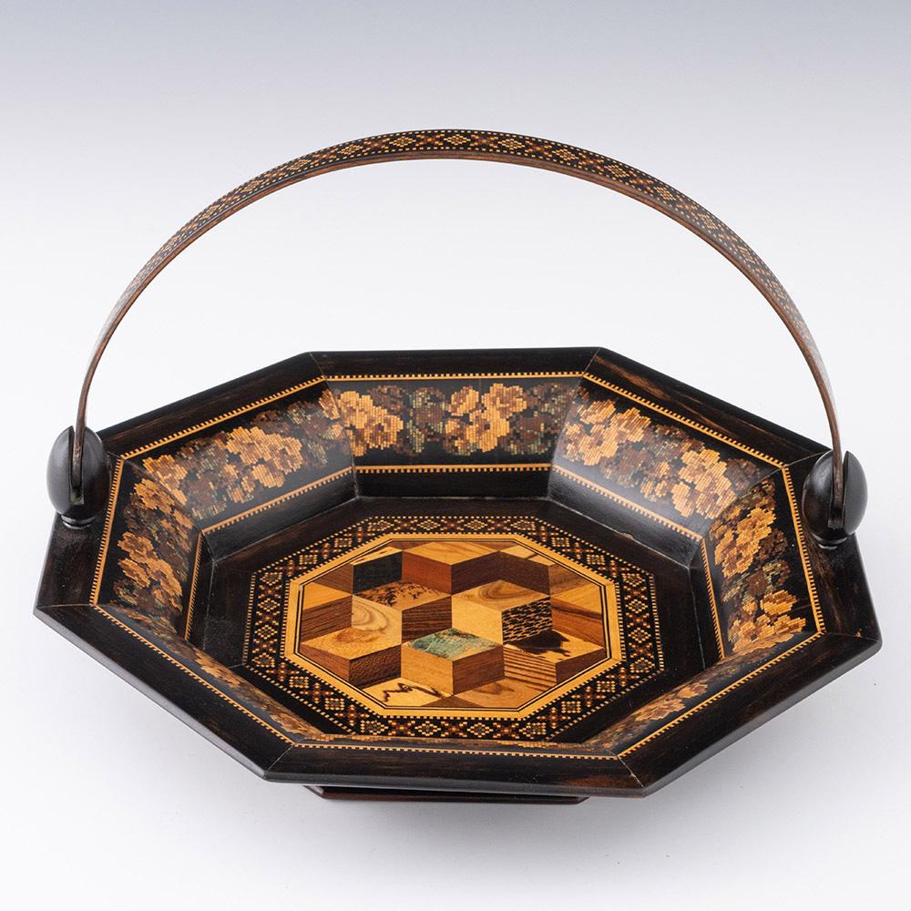 Heading : Tunbridge ware sewing basket with cubework design

Date : c1875

Period : Victoria

Origin : Tunbridge Wells, Kent

Decoration : Central perspective cubework design with geometric border. Side panels with floral banding and dentil