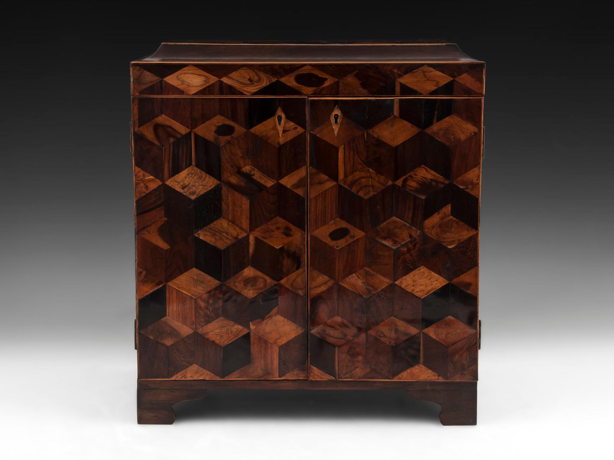 Large Tunbridge ware sewing cabinet with cube perspective design on the front and top, made from various exotic woods including coconut wood, tulipwood, kingwood, and Coromandel.

Once unlocked the top can be lifted to reveal a ruched silk backing
