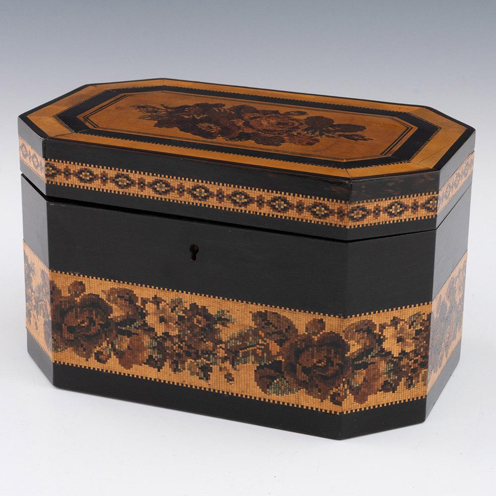 Titolo : Porta tè Tunbridge Ware di Thomas Barton, 1870 ca.

Data: c1870

Periodo : Vittoria

Origine : Tunbridge Wells, Kent

Decorazione: Mosaico floreale centrale con incorniciatura a dentelli. I pannelli laterali del coperchio presentano una