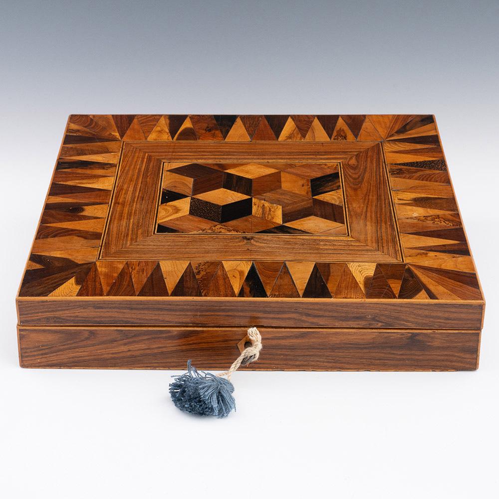 Heading : Tunbridge ware writing slope with cubework

Date : c1840

Period : Victoria

Origin : Probably Tunbridge Wells, Kent

Decoration : Central perspective cubework with van dyke triangles to border. Interior lined with pink paper and a felt