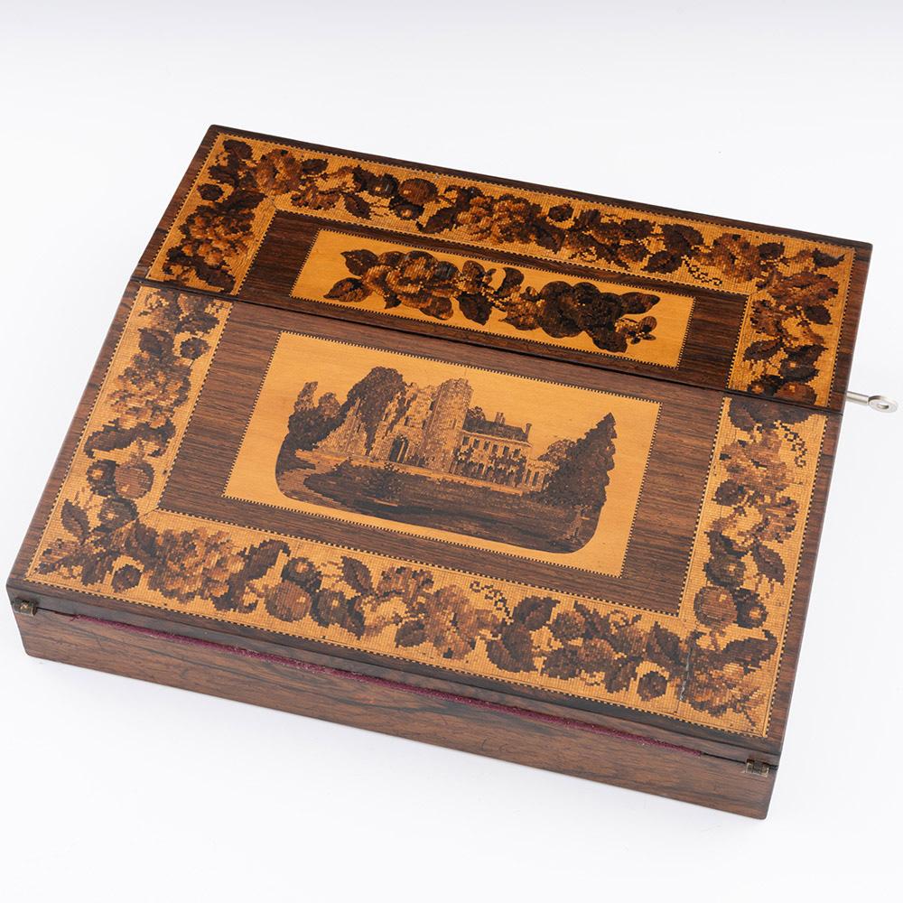 Heading : Tunbridge ware writing slope with image of Tonbridge Castle by Thomas Barton c1875

Date : c1875

Period : Victoria

Origin : Tunbridge Wells, Kent

Decoration :Main panel of cover with image of Tonbridge Castle below a floral mosaic.