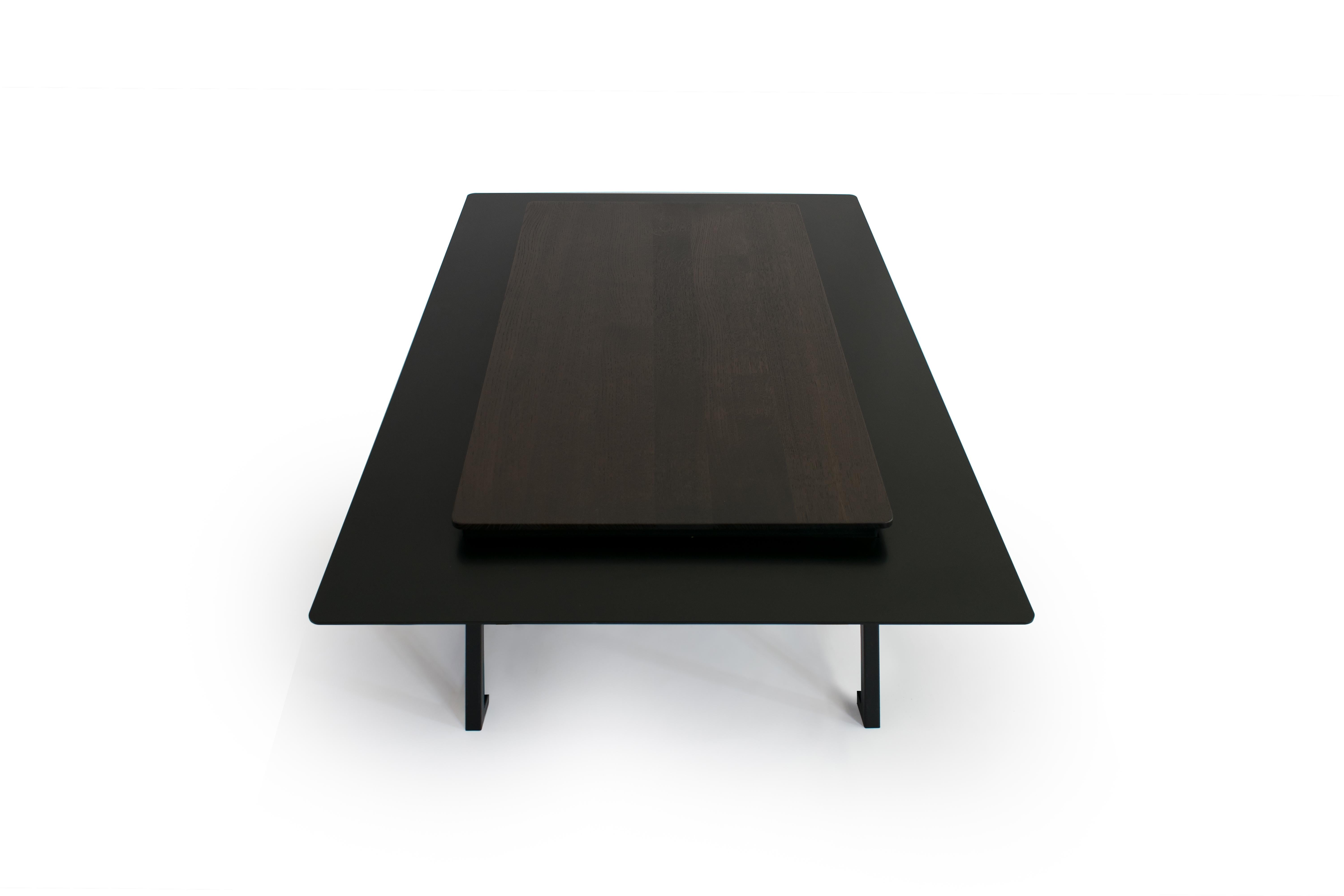 Tungen Coffee Table, Jan Garncarek
Materials: Steel, wood.
Dimensions: 33 x 130 x 80 cm.
Weight: 60 kg

The table consists of a wood top with a metal collar. This will enable the separation of everyday objects from those, that we want to expose on