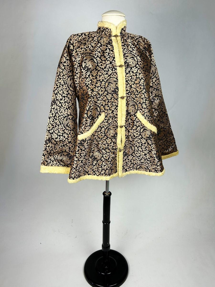 Circa 1930-1940
China

Beautiful black and gold silk lampas tunic jacket fully lined with short-haired curly lamb fur dating from 1930-1940. Wide, tapered cut, slit at the sides, with Kimono sleeves and small Mao collar. Front fastening with five