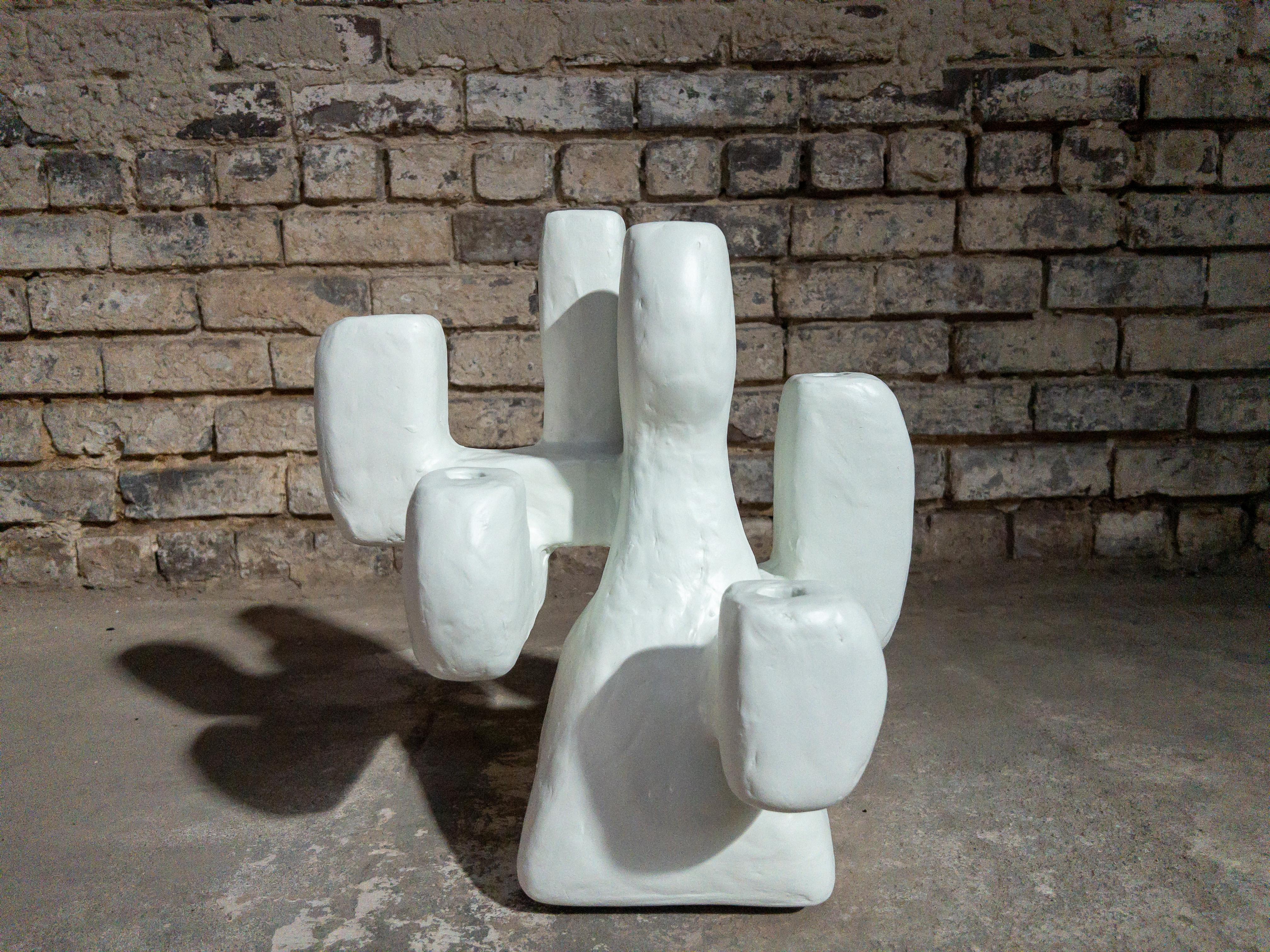 The Tunnel Candelabra by Brent Warr is an evocative fusion of sculpture and function. With its softened geometric limbs and matte white finish, the piece conjures a sense of movement and spatial rhythm. Crafted from a layered composite and sealed