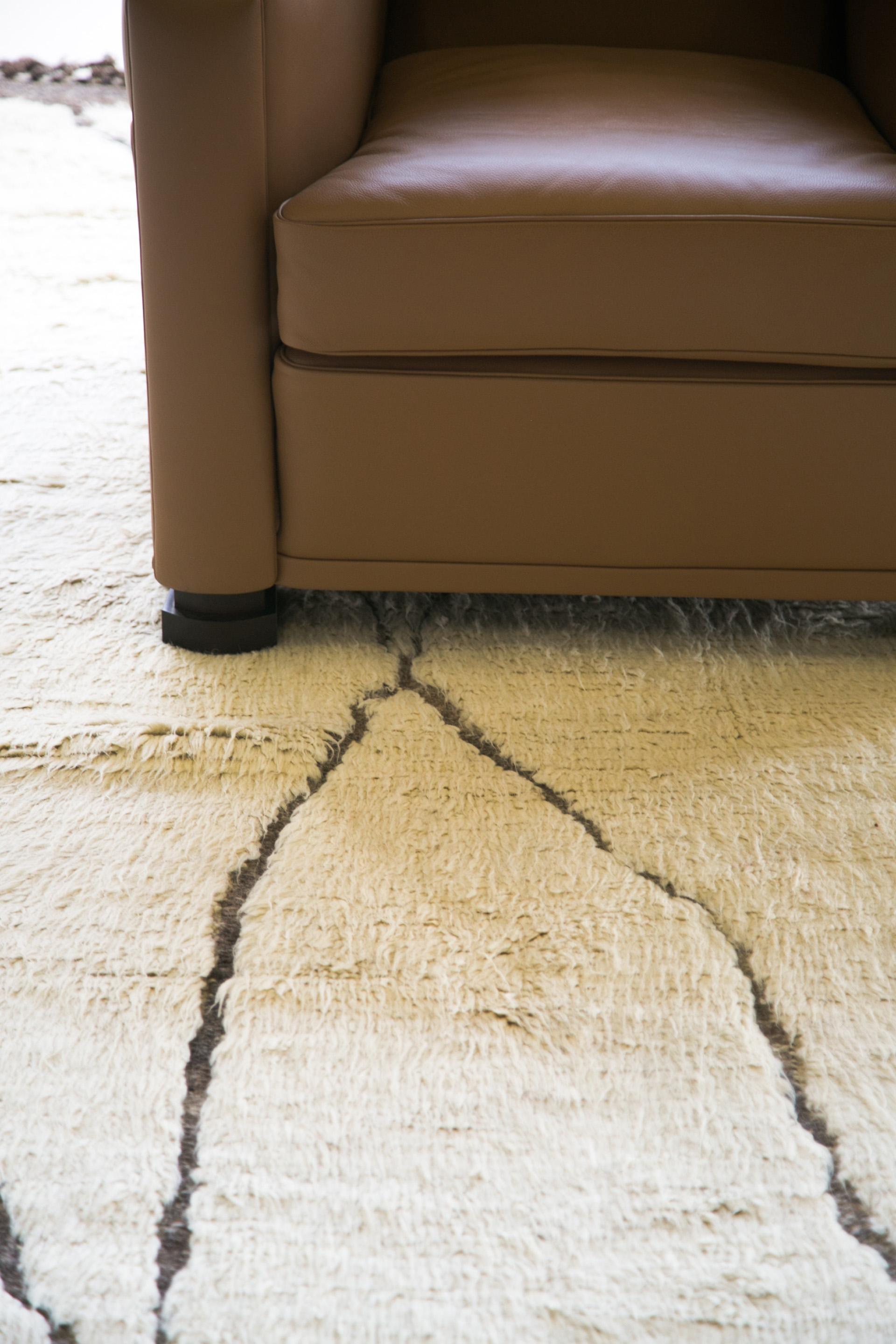 Tessuto a mano in lussuosa lana nella perfetta tonalità del bianco con dettagli in rilievo su una trama piatta marrone naturale, questo disegno è un'interpretazione contemporanea di un tappeto tribale marocchino ricreato per il mondo del design