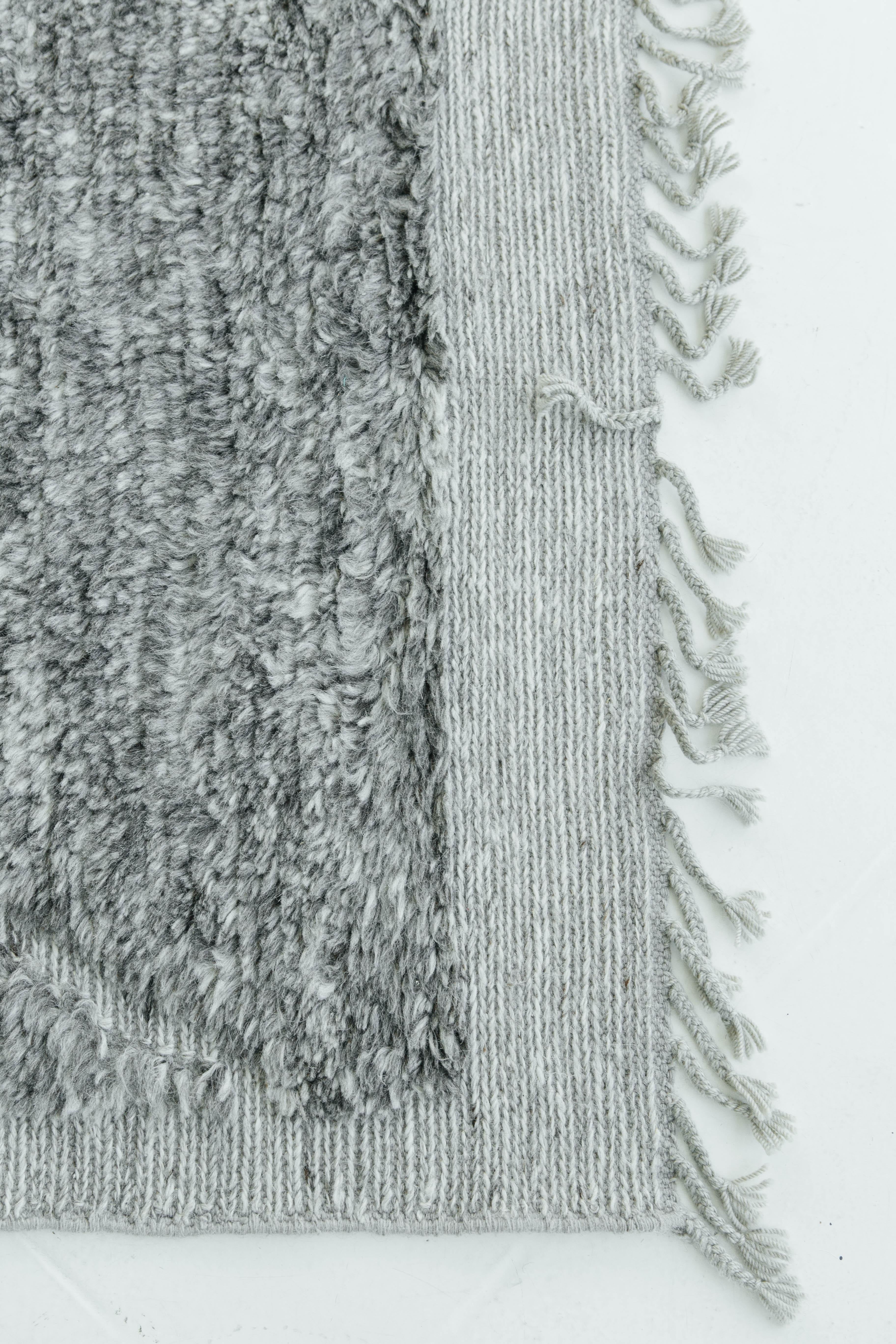 Handwoven of luxurious wool in the perfect shade of pewter with embossed detailing over a natural light-gray flat-weave, this design is a contemporary interpretation of a Moroccan tribal rug recreated for the modern design world. Tunner was crafted