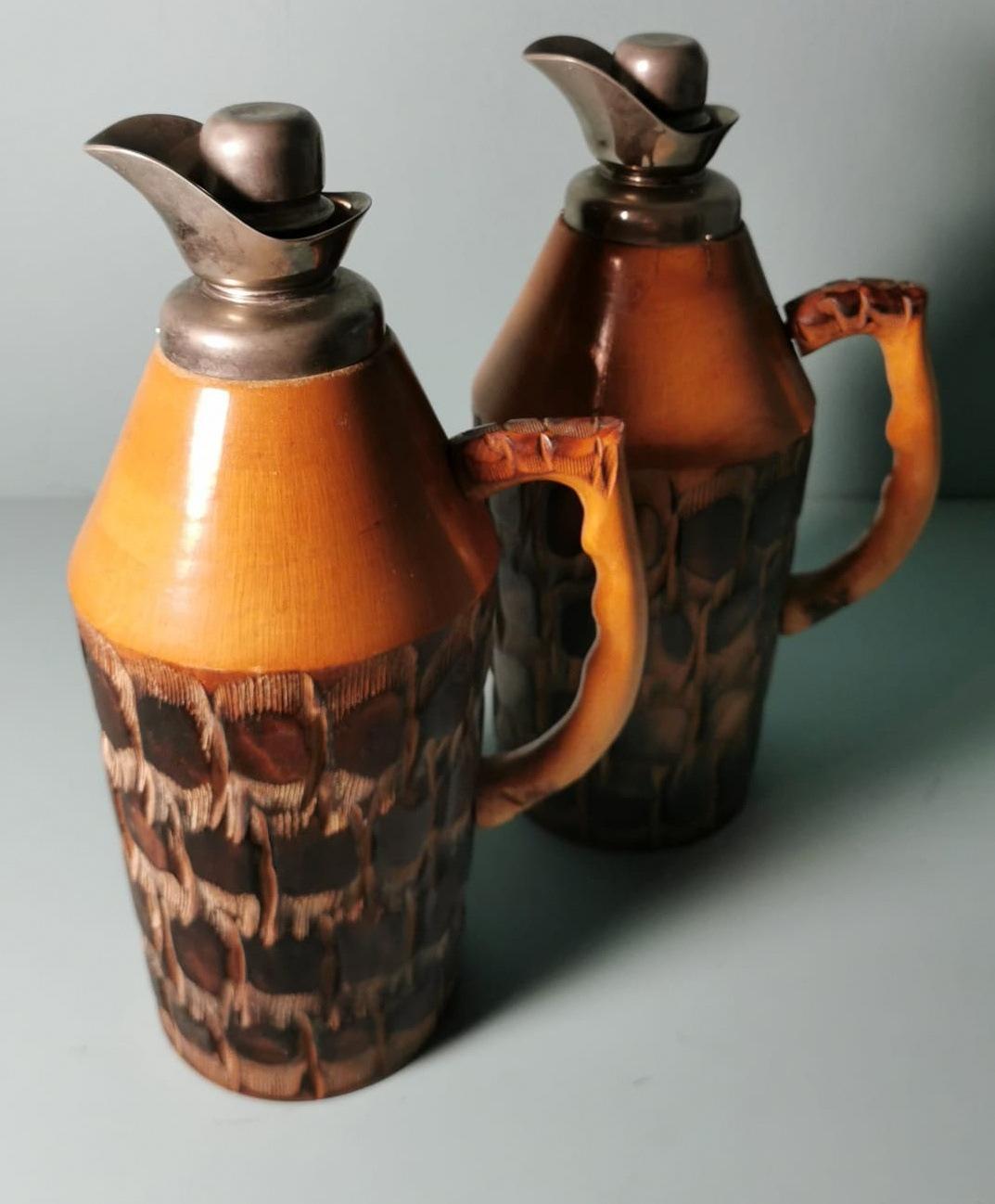 We kindly suggest that you read the entire description, as we aim to provide detailed technical and historical information to guarantee the authenticity of our objects.
This original and iconic pair of thermal jugs features a frame made of sturdy