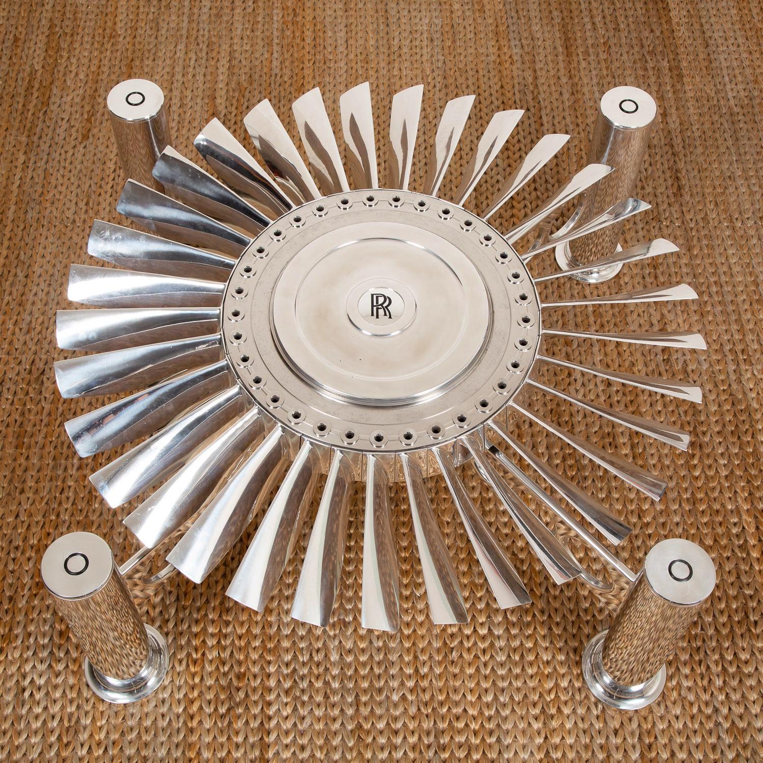 Coffee table Turbofan Rolls-Royce with turbine from
Rolls-Royce RB.80 Conway engine. With 110cm diameter
turbine in titanium which rotates under the glass top on
a polished aluminium base. With clear glass top, 
15mm thickness. Exceptional