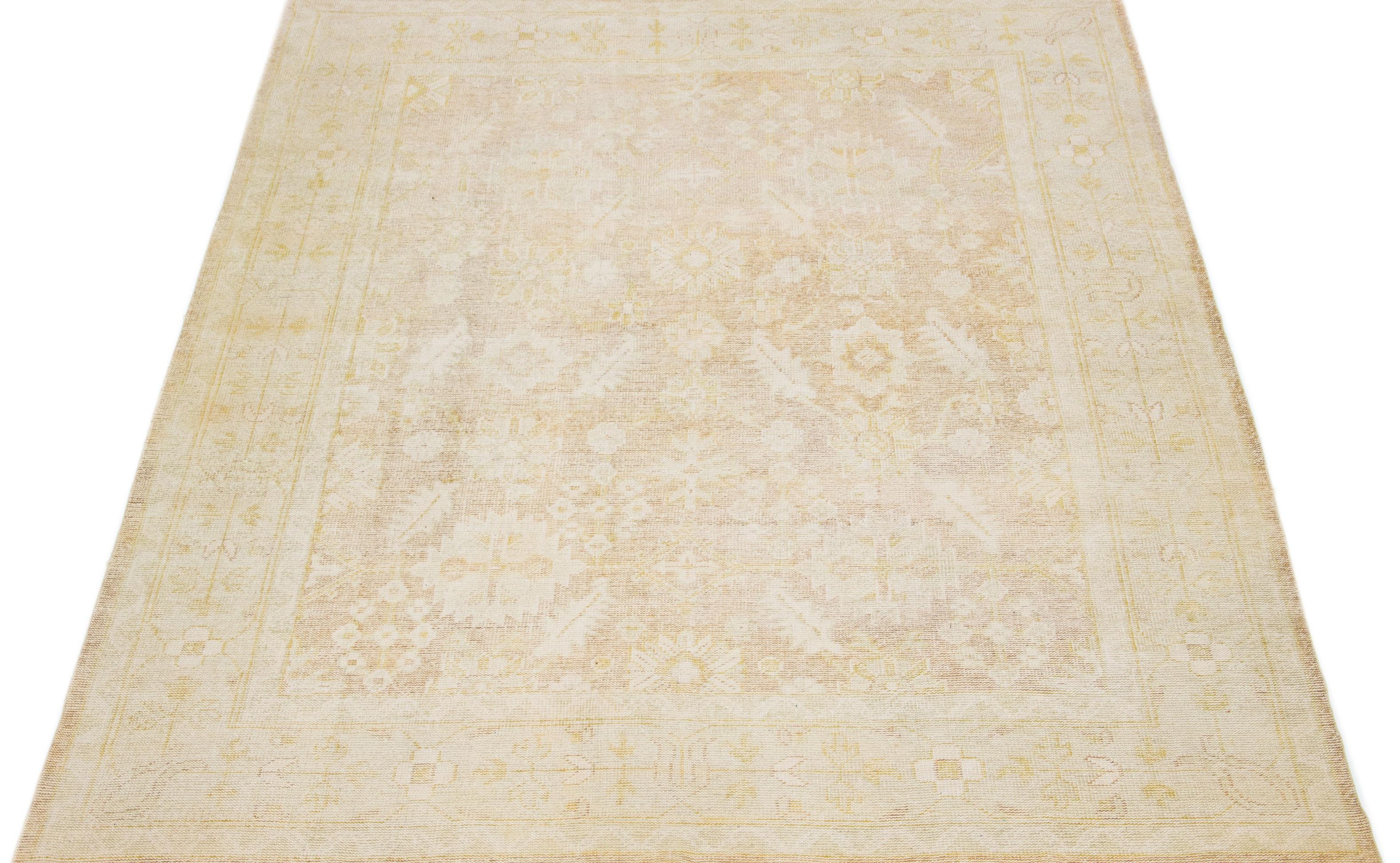 Cet exceptionnel style ancien  Le tapis en laine turque présente une charmante base de couleur beige et est noué à la main avec la plus grande attention aux détails. Avec de superbes accents ivoire, il affiche un motif floral captivant qui s'intègre