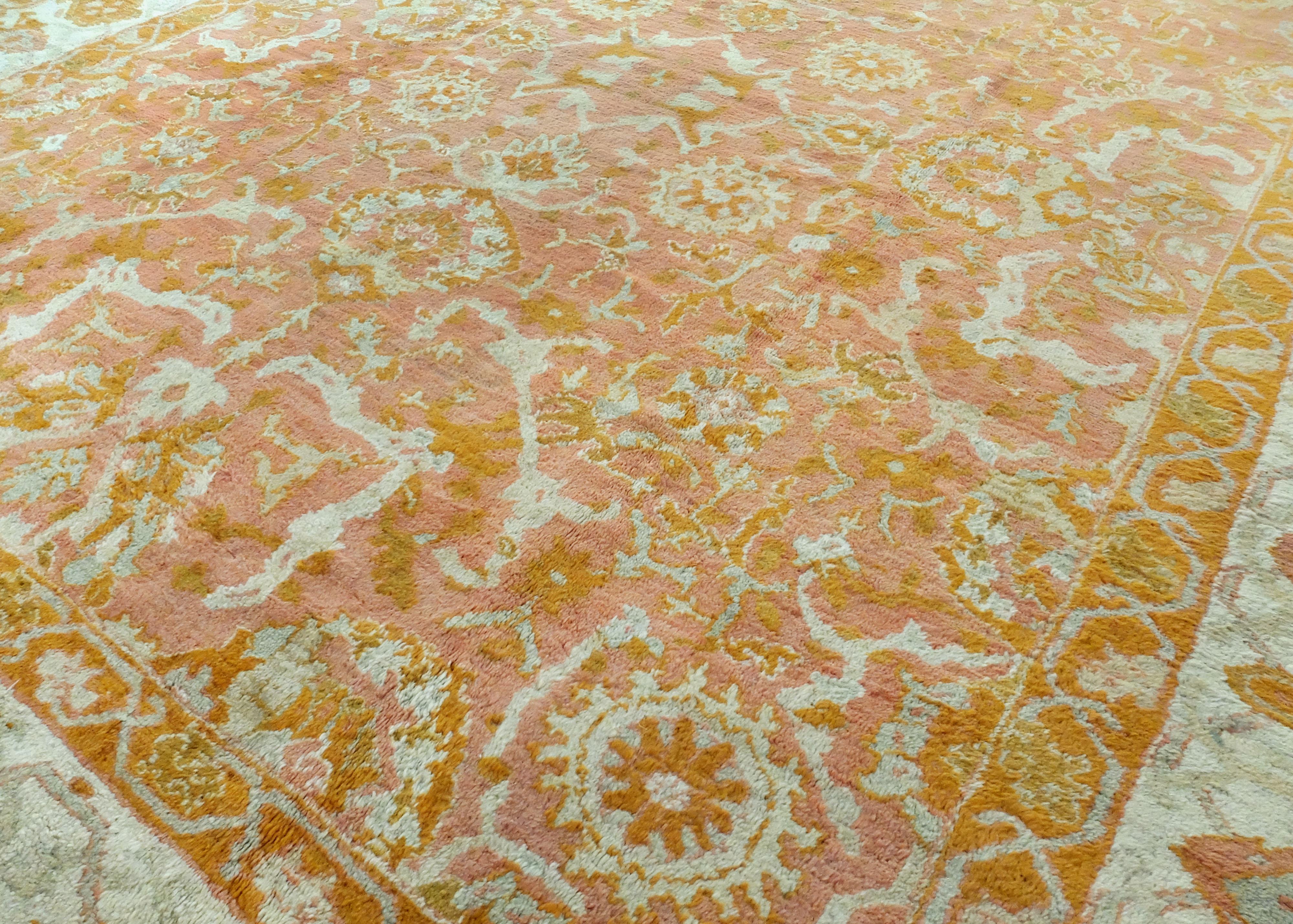 Il s'agit d'un tapis turc Beaulieu Oushak fabriqué vers les années 1890. Il présente une délicate palette de couleurs pêche, crème et or. Le centre du tapis présente de grandes formes florales abstraites qui sont entourées de quatre bordures à