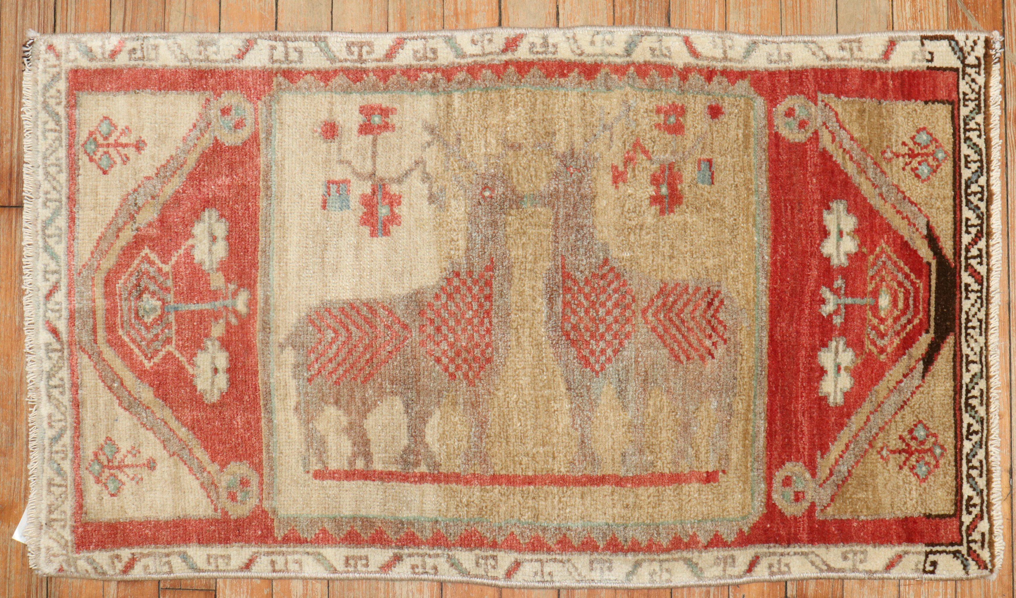 Tapis turc du milieu du 20e siècle représentant deux cerfs sur un champ de chameaux. 

Mesures : 1'10'' x 3'2''.