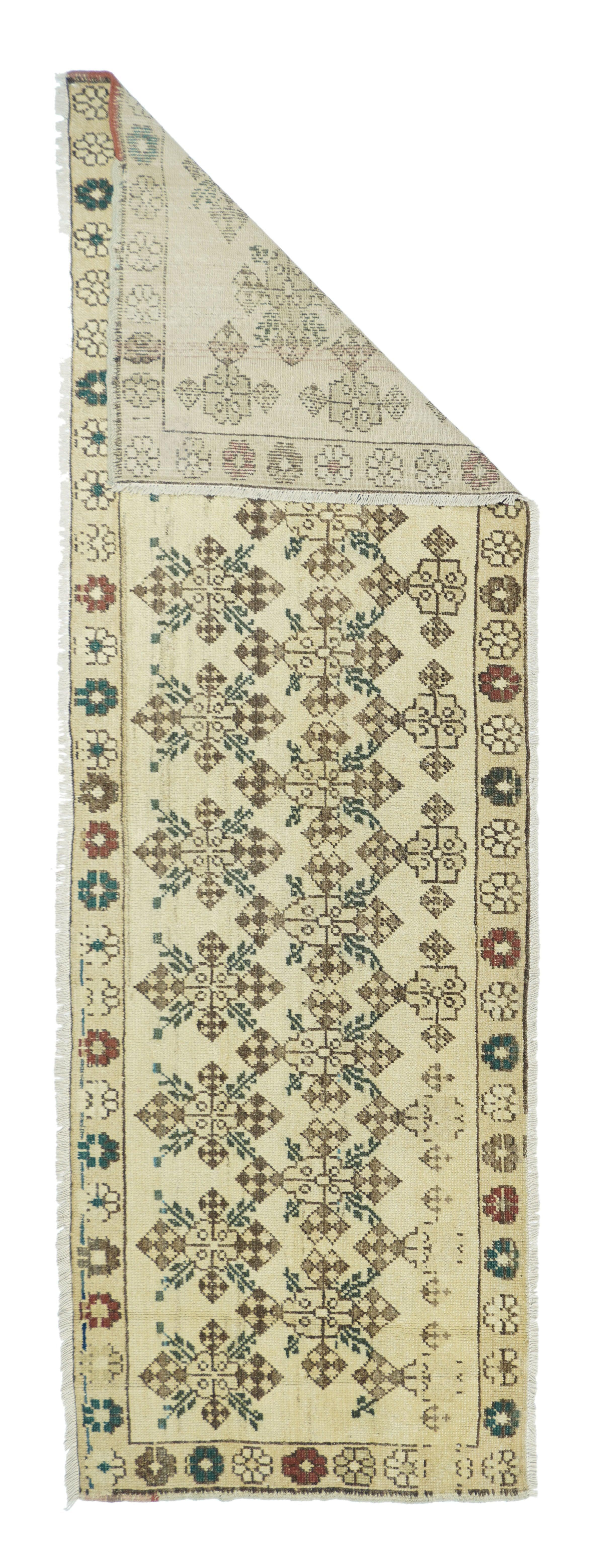 Runner turco geometrico 2'6'' x 7'10''.  Questo Kenare (runner) presenta un campo di paglia insolitamente sbilanciato con due colonne sfalsate di gul floreali stilizzati a scacchiera spinti da un lato per lasciare spazio ad accenti rossi, marrone