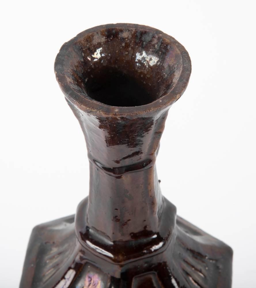 A very interesting 19th century late ottoman ceramic bottle-form vase. The unusual six sided body with geometric decorated panels supported by a round base and topped with a trumpet-form neck. Covered in a rich chocolate brown glaze.