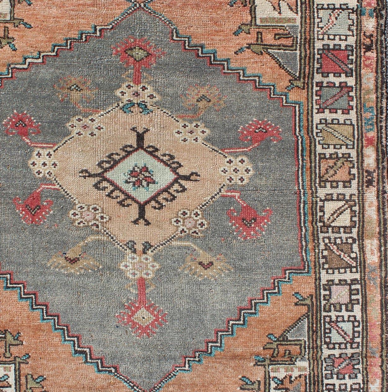 Alfombra pequeña vintage Oushak de Turquía en naranja claro y gris claro, alfombra/TU-TRS-136585, Keivan Woven Arts / país de origen / tipo: Turquía / Oushak, hacia 1950

Esta alfombra turca oushak vintage presenta un medallón de intrincado diseño