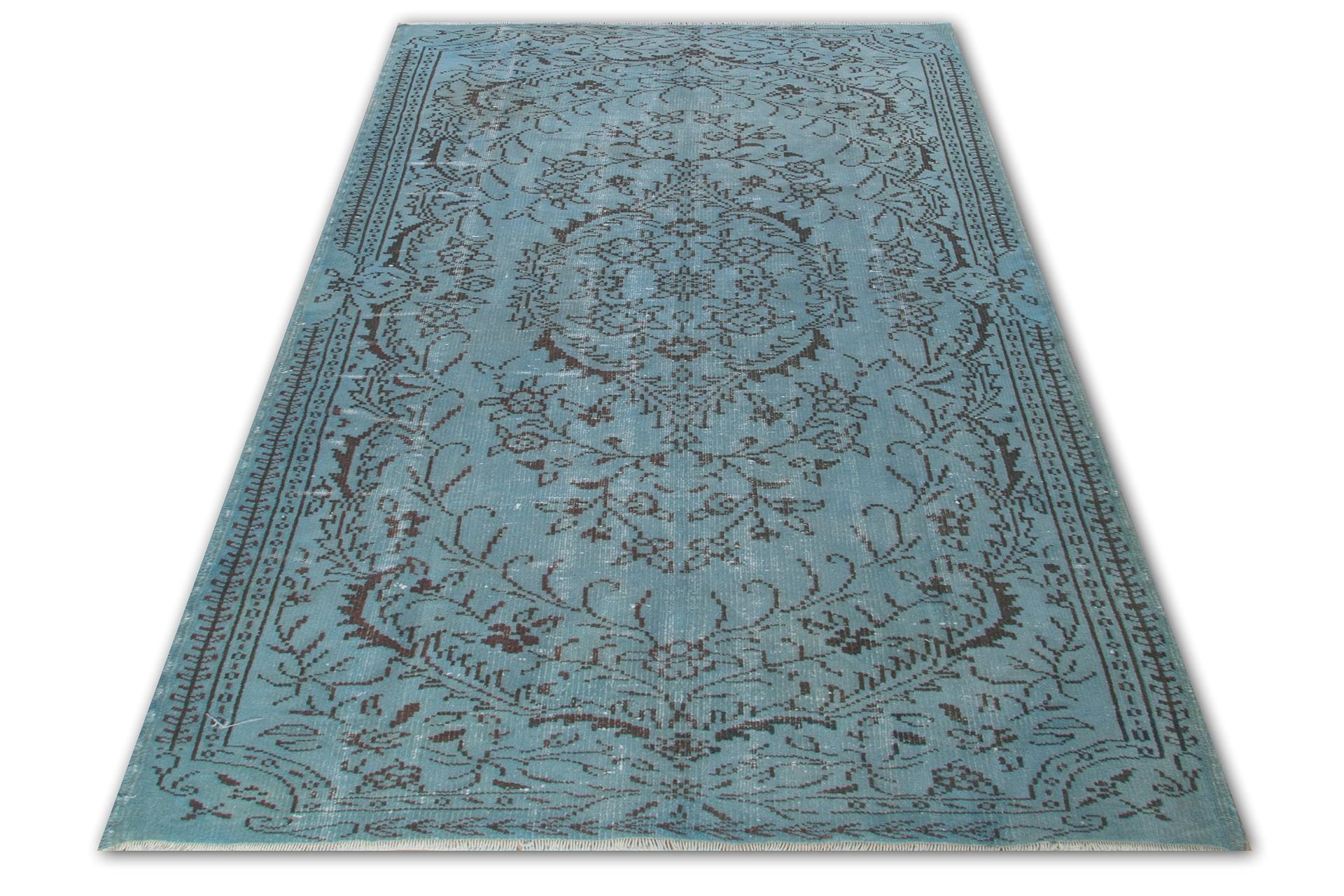 This hand knotted Turkish rug was originally made in the 1960s. It is over-dyed in soft cerulean blue and has low wool pile on cotton foundation. It is very sturdy, clean and in good condition. It features a floral medallion against a field