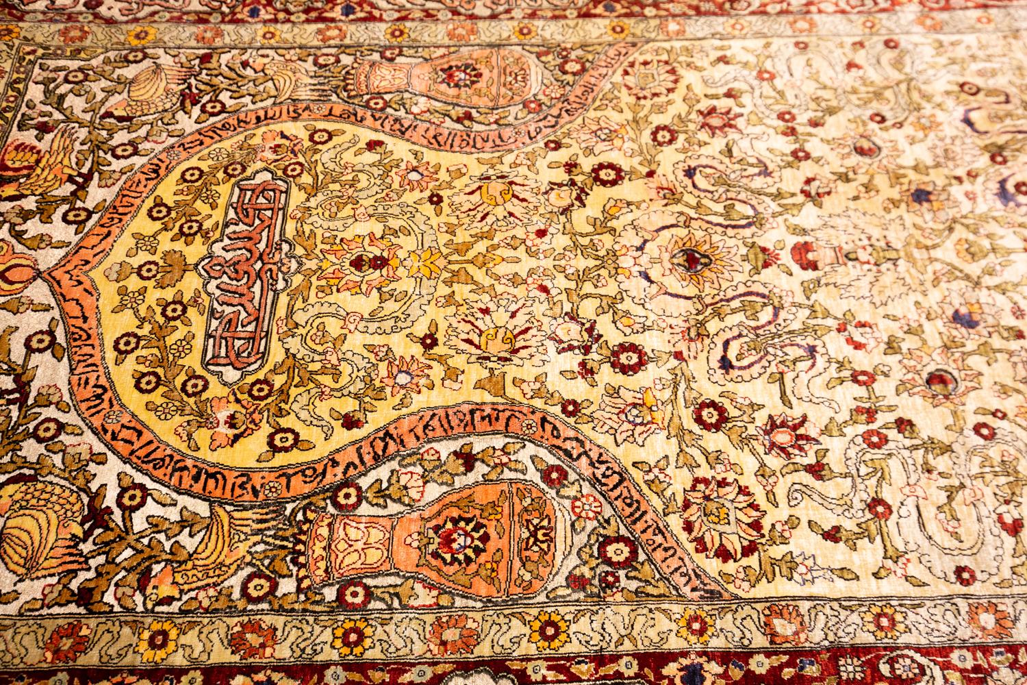 This is a silk souf Hereke with metal threads woven in Turkey during the fourth quarter of the 20th century and measures 157 x 98 cm in size. This rug has a mihrab design with scriptures from the Quran. The field is decorated with palmettes