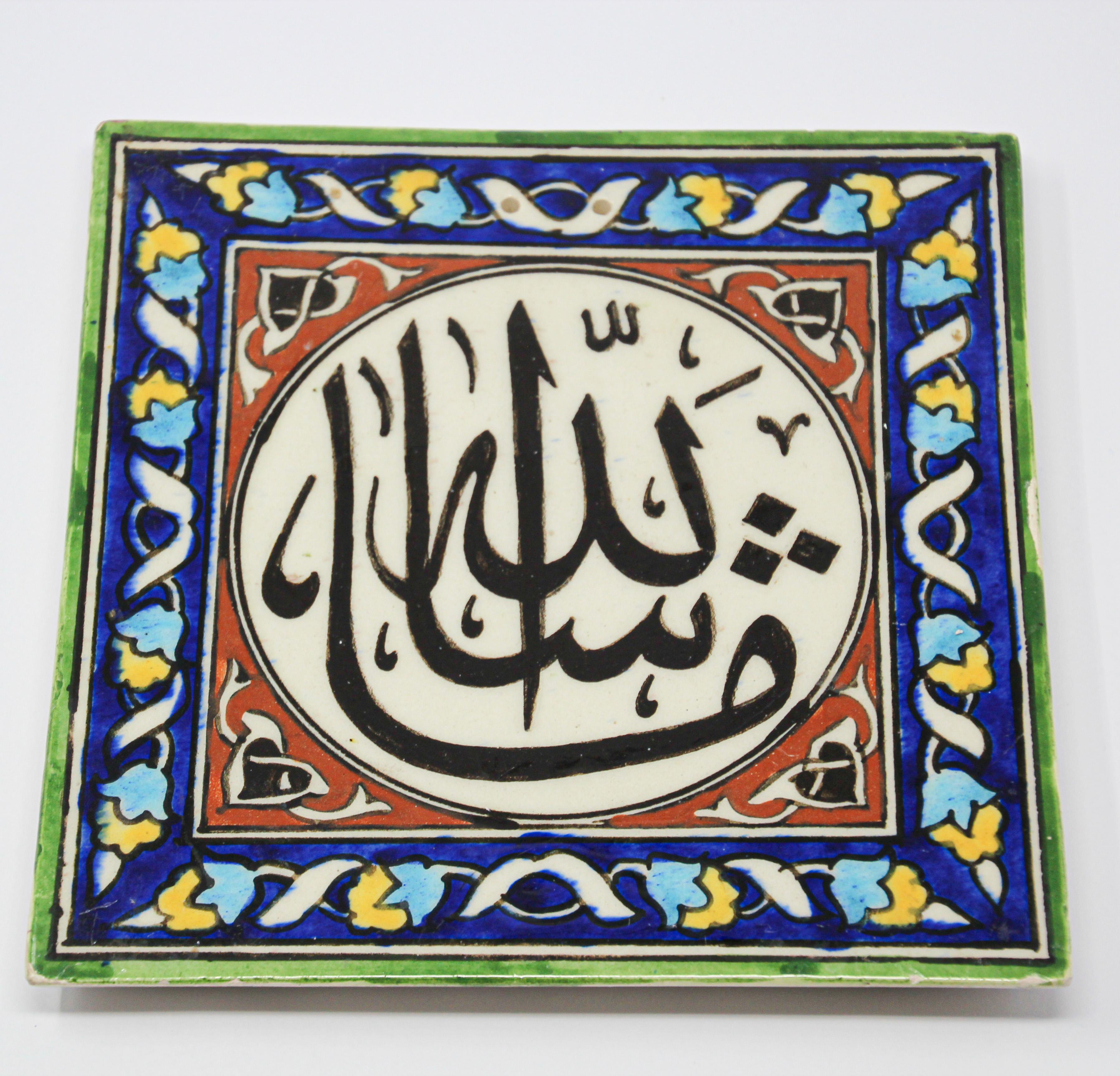 Turkish handcrafted decorative tile with hand painted Islamic Koranic blessing and floral design.
Ceramic Islamic tile hand painted with Arabic Islamic writing and flowers.
Writing in Arabic says the following.
