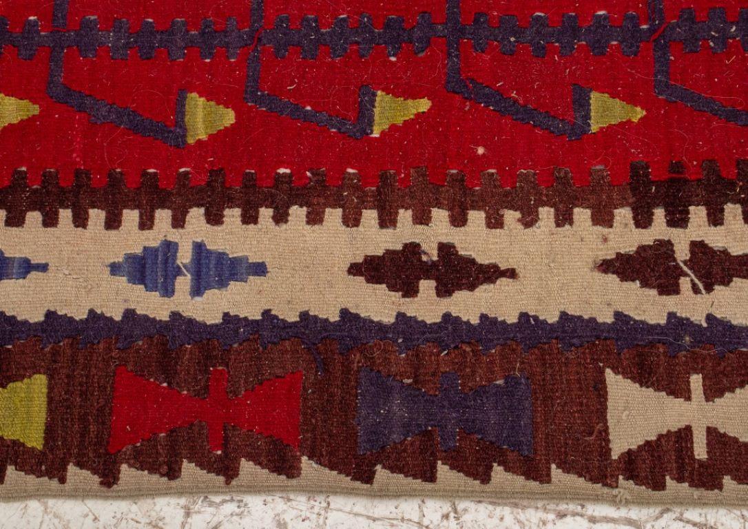 Turkish hand-woven kilim carpet with polychrome geometric design on a red ground. 

Dealer: S138XX