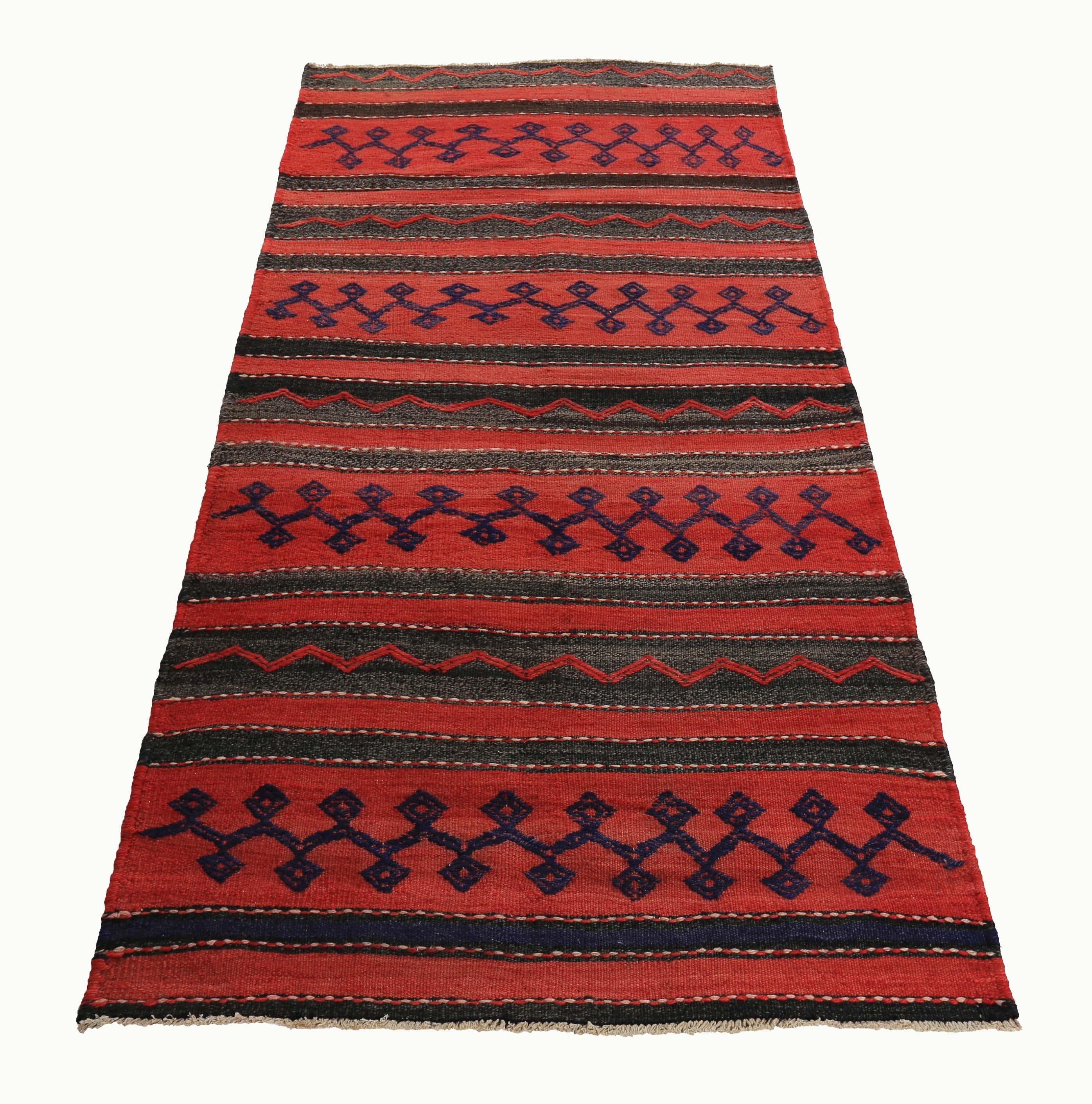 Turkish rug handwoven from the finest sheep’s wool and colored with all-natural vegetable dyes that are safe for humans and pets. It’s a traditional Kilim flat-weave design featuring a red and black field with tribal stripes in navy. It’s a stunning