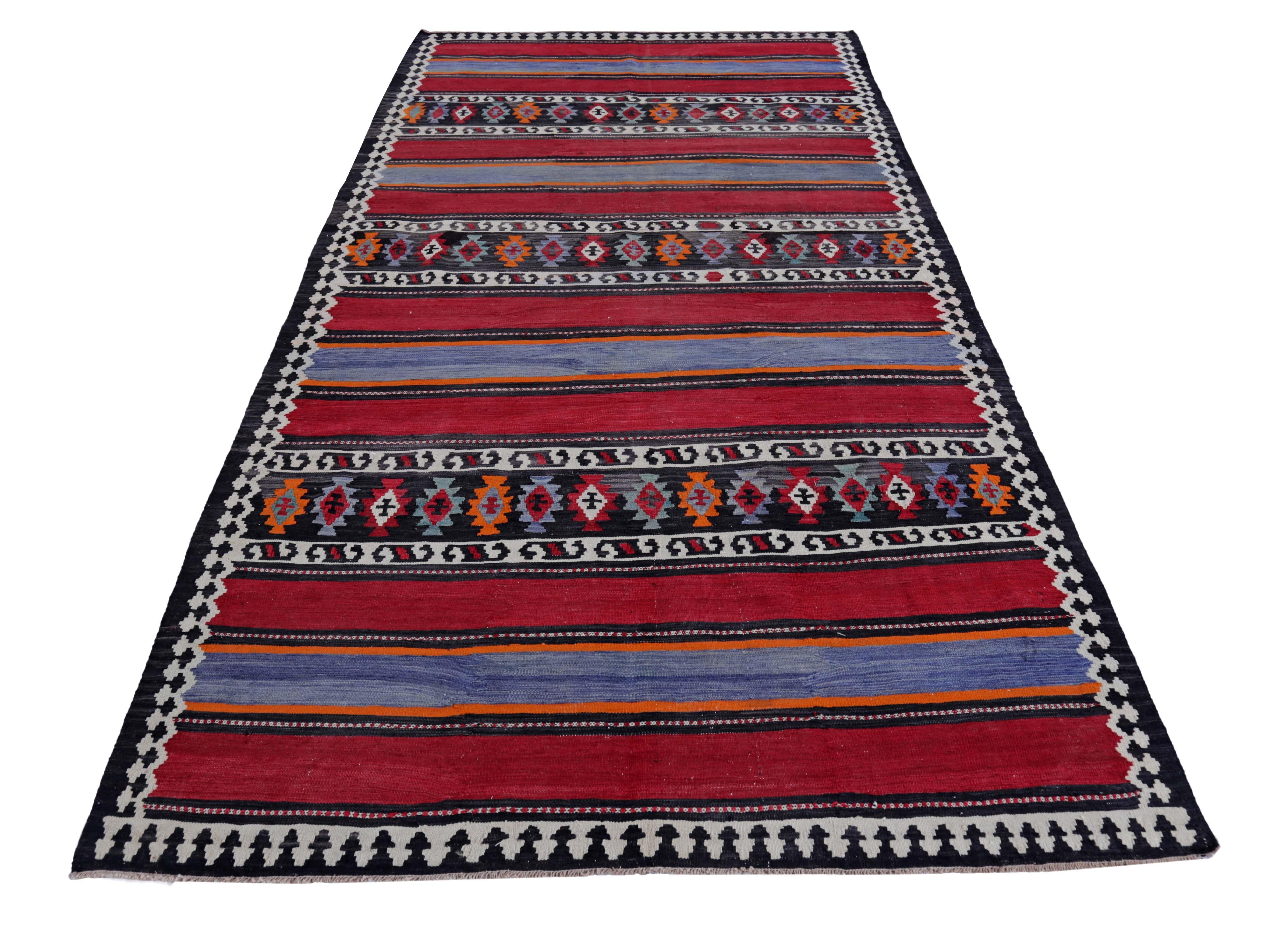 Turkish rug handwoven from the finest sheep’s wool and colored with all-natural vegetable dyes that are safe for humans and pets. It’s a traditional Kilim flat-weave design featuring a black field with tribal stripes in red, white and navy. It’s a