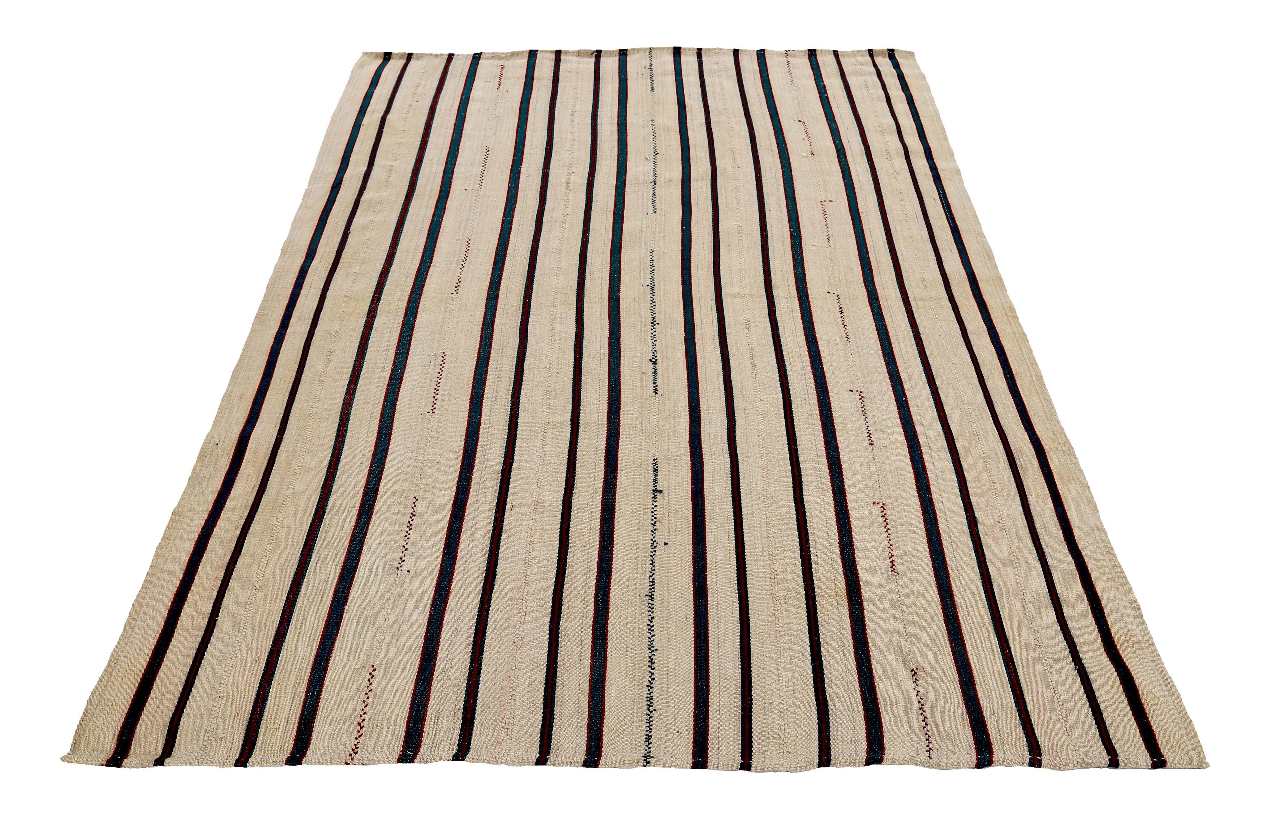 Turkish runner rug handwoven from the finest sheep’s wool and colored with all-natural vegetable dyes that are safe for humans and pets. It’s a traditional Kilim flat-weave design featuring a red and green stripes over an ivory field. It’s a