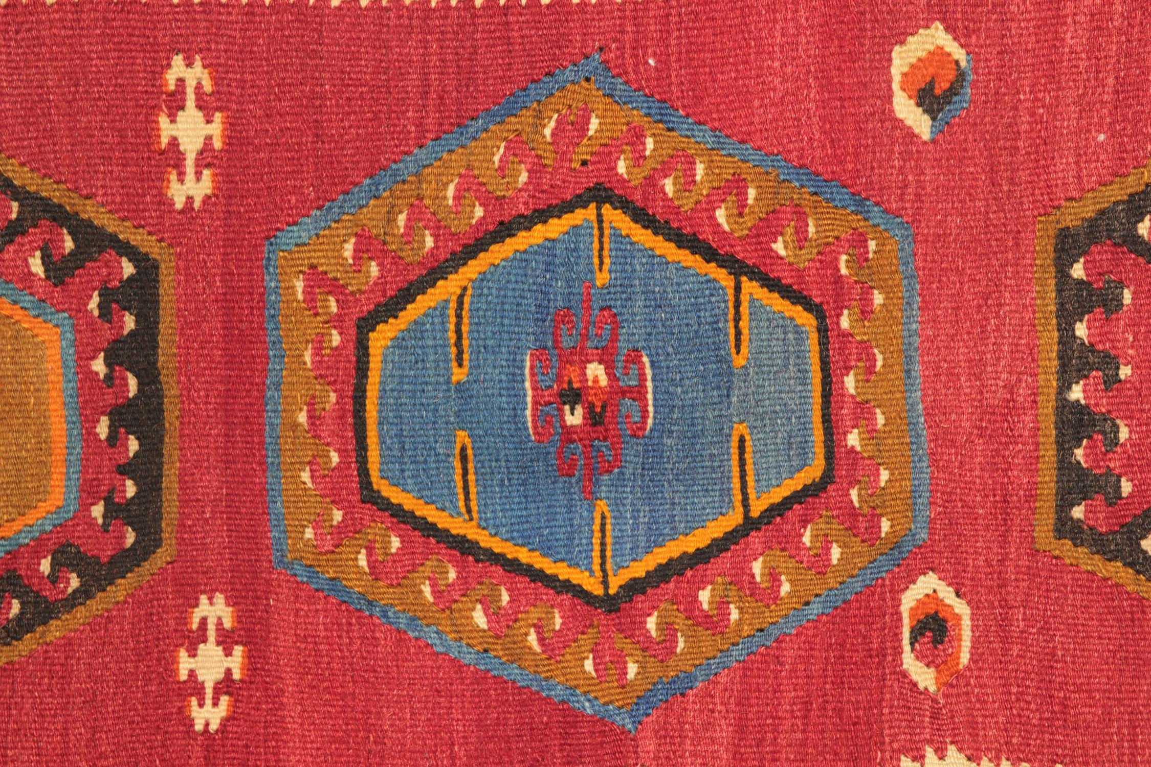 Dieser türkische Kilim-Teppich aus den 1940er Jahren ist ein außergewöhnliches Beispiel für anatolische Flachgewebe, das sich durch seine kühnen geometrischen Medaillons und seine satte Farbpalette auszeichnet. Das aus natürlicher Wolle handgewebte
