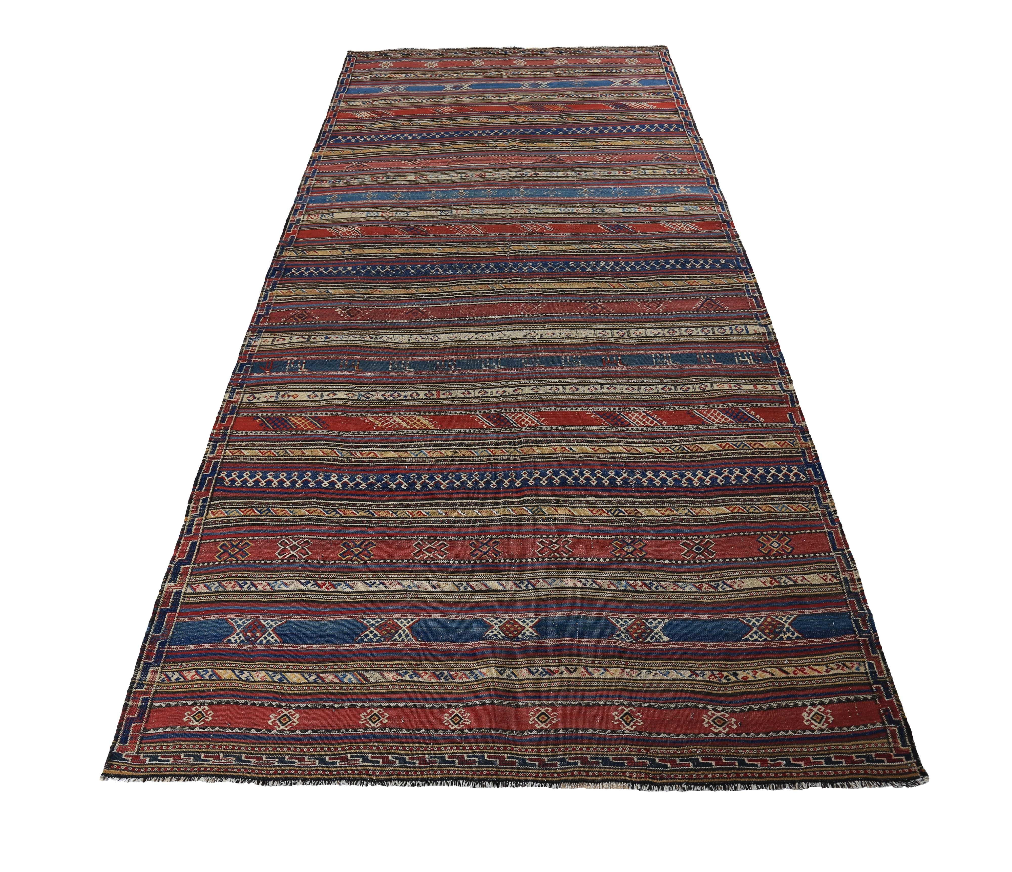 Turkish rug handwoven from the finest sheep’s wool and colored with all-natural vegetable dyes that are safe for humans and pets. It’s a traditional Kilim flat-weave design featuring navy and red stripes decorated with tribal details. It’s a
