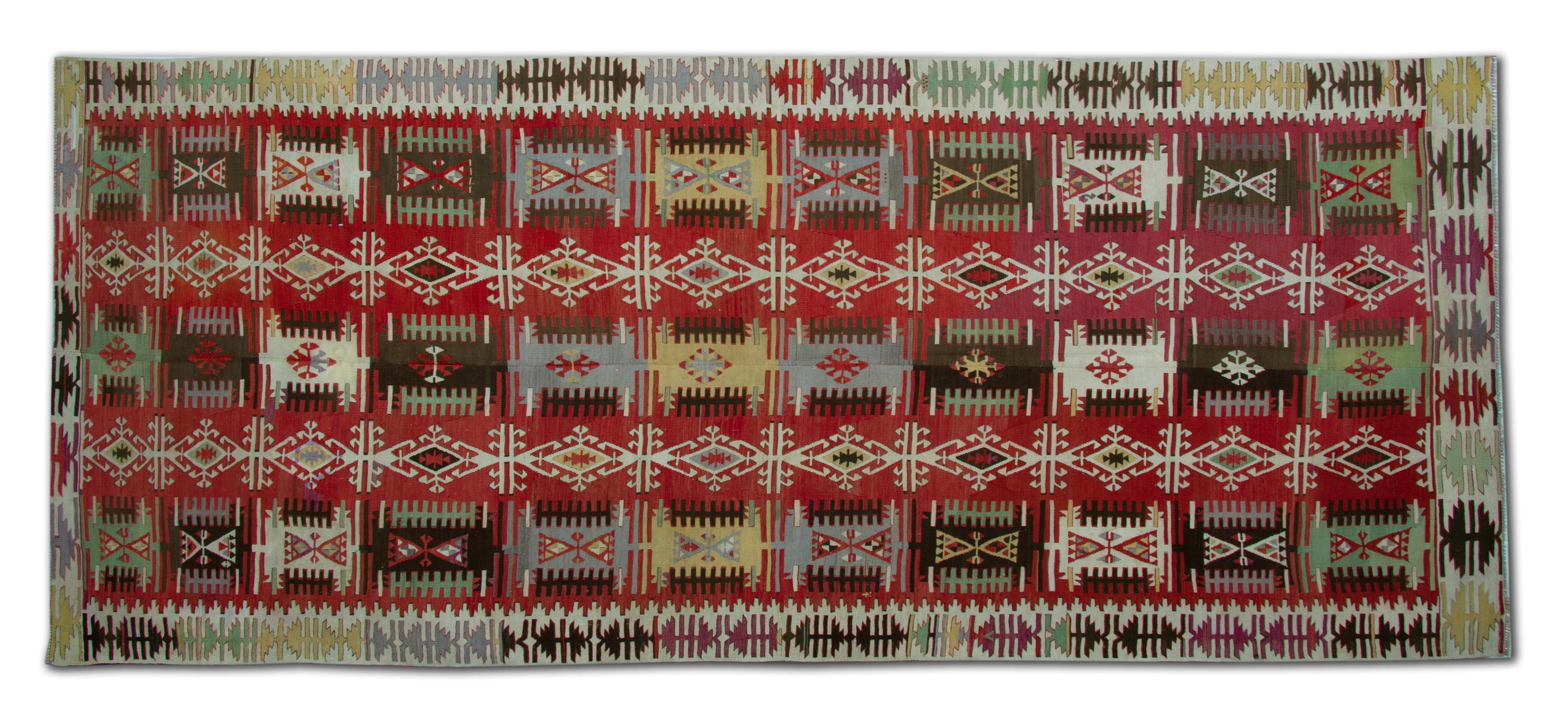 Dieser außergewöhnliche antike türkische Kilim-Läufer ist ein seltener handgefertigter Wollteppich aus den 1890er Jahren, der mit unglaublicher Handwerkskunst, leuchtenden Stammesfarben und authentischen geometrischen Mustern gewebt wurde. Mit den