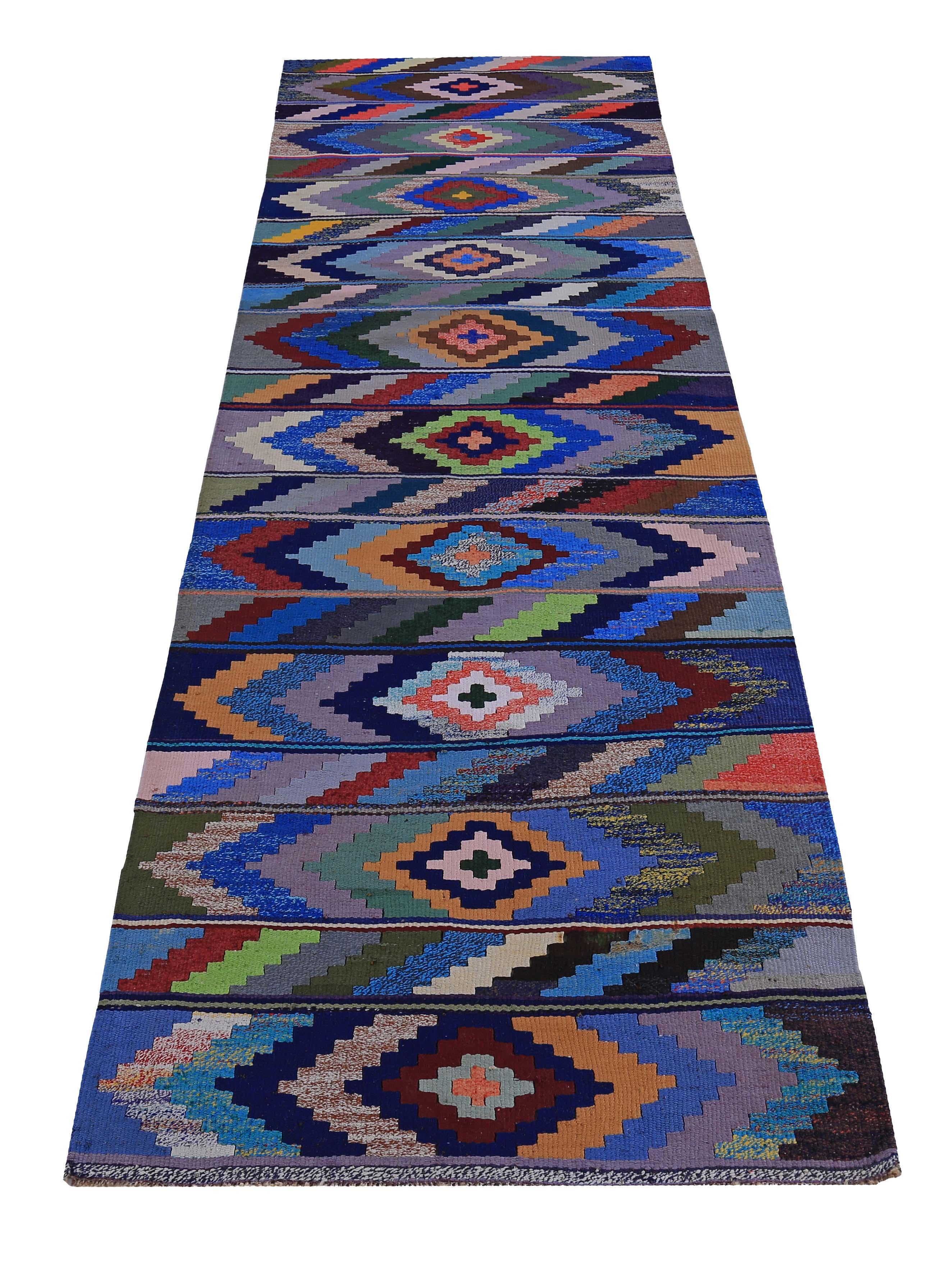 Turkish runner rug handwoven from the finest sheep’s wool and colored with all-natural vegetable dyes that are safe for humans and pets. It’s a traditional Kilim flat-weave design featuring blue, orange and brown tribal diamond patterns. It’s a