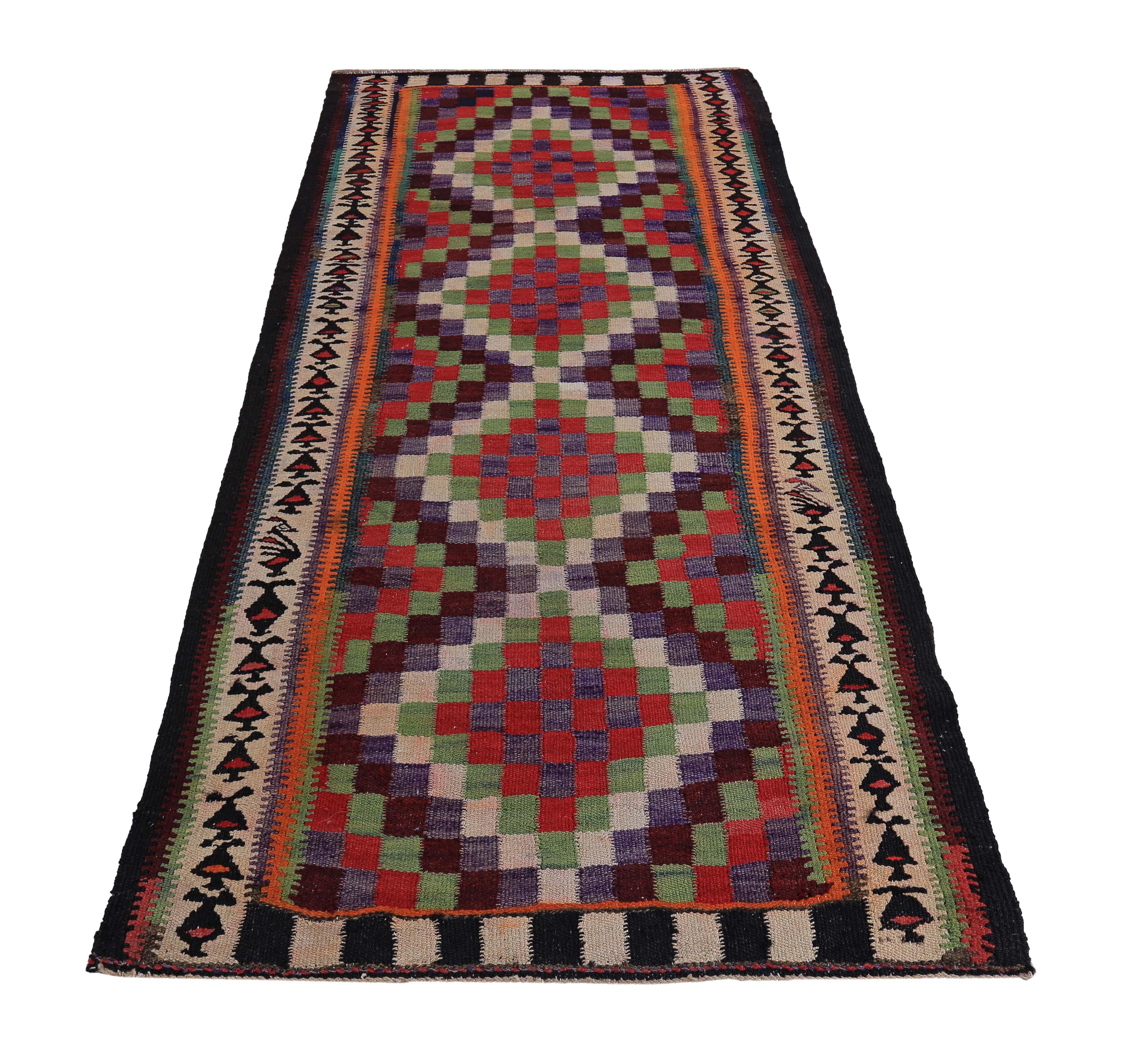 Turkish runner rug handwoven from the finest sheep’s wool and colored with all-natural vegetable dyes that are safe for humans and pets. It’s a traditional Kilim flat-weave design featuring orange, blue, red and green in a checkered pattern. It’s a
