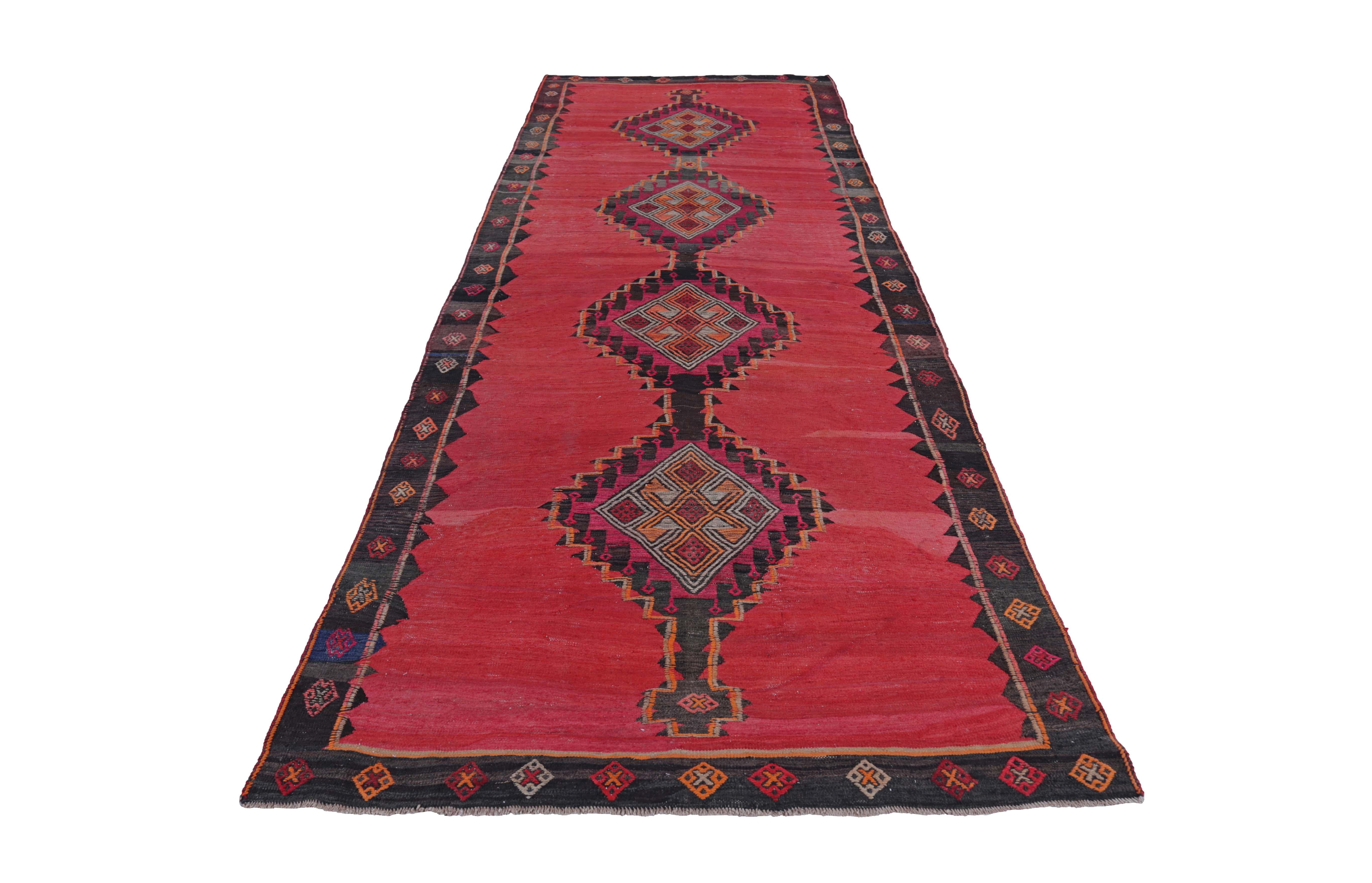 Turkish Kilim runner rug handwoven from the finest sheep’s wool and colored with all-natural vegetable dyes that are safe for humans and pets. It’s a traditional Kilim flat-weave design featuring red, black and orange diamond patterns. It’s a