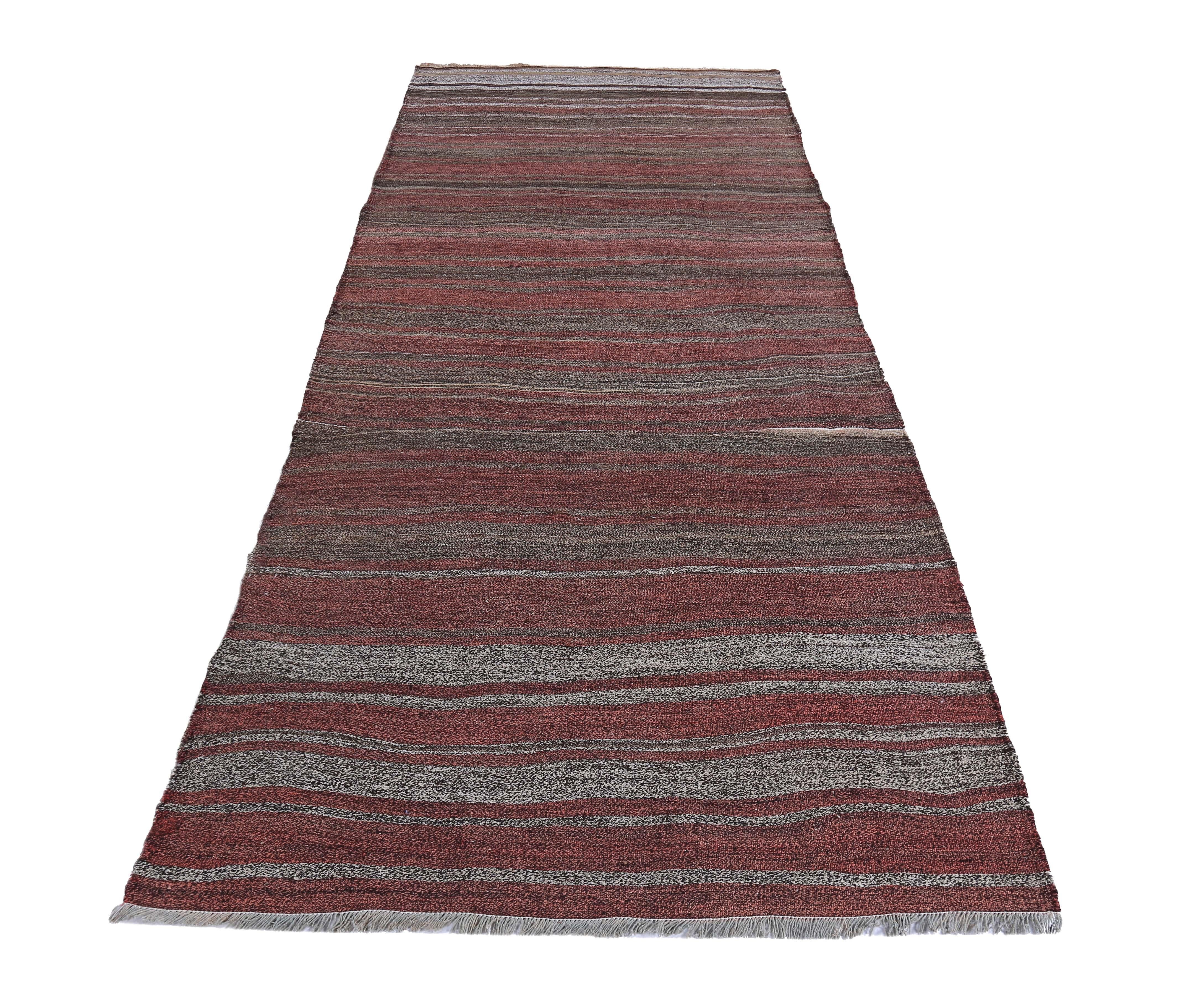 Turkish runner rug handwoven from the finest sheep’s wool and colored with all-natural vegetable dyes that are safe for humans and pets. It’s a traditional Kilim flat-weave design featuring red, gray and brown stripe patterns. It’s a stunning piece