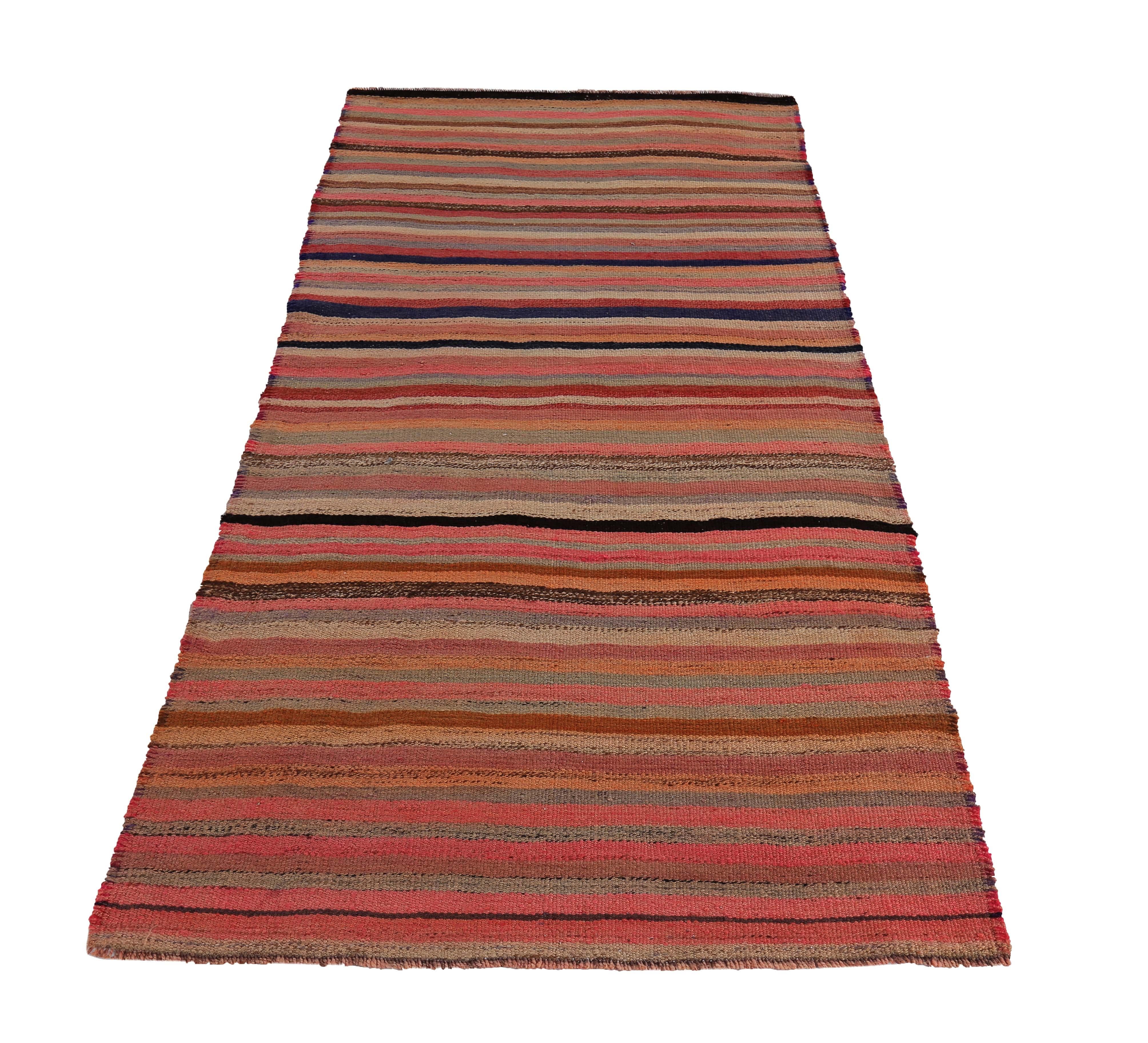 Turkish runner rug handwoven from the finest sheep’s wool and colored with all-natural vegetable dyes that are safe for humans and pets. It’s a traditional Kilim flat-weave design featuring red, orange and pink stripe patterns. It’s a stunning piece