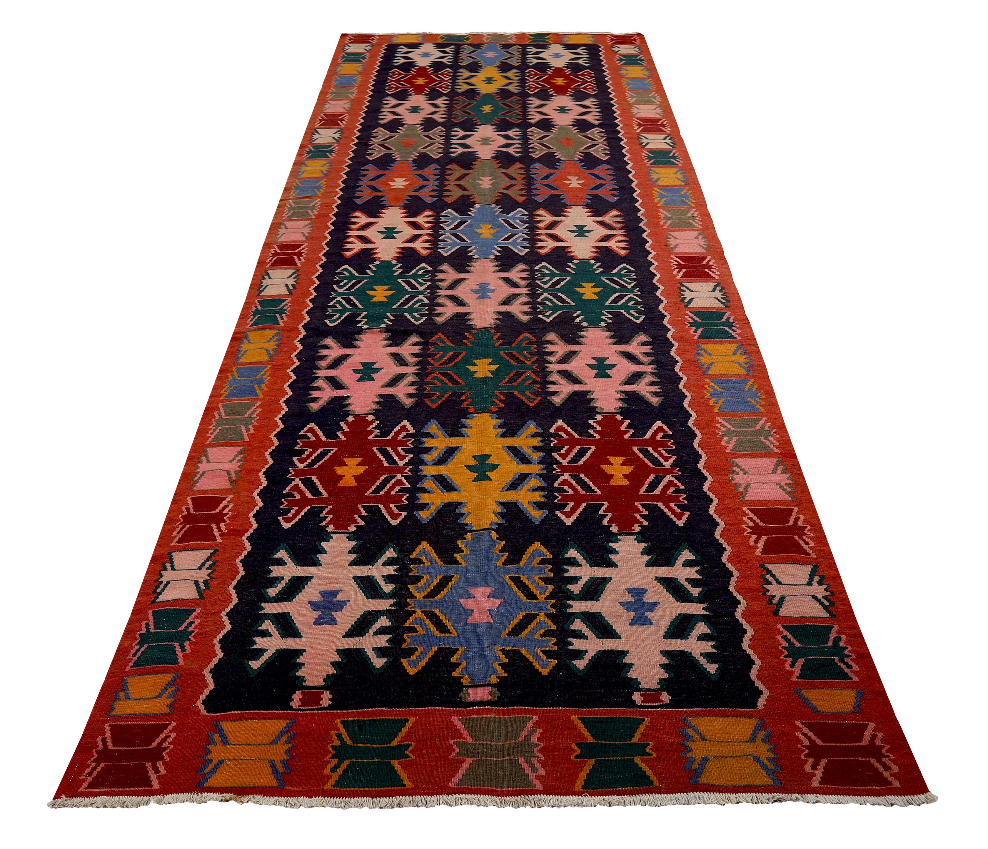 Turkish runner rug handwoven from the finest sheep’s wool and colored with all-natural vegetable dyes that are safe for humans and pets. It’s a traditional Kilim flat-weave design featuring green, blue, and pink tribal details. It’s a stunning piece