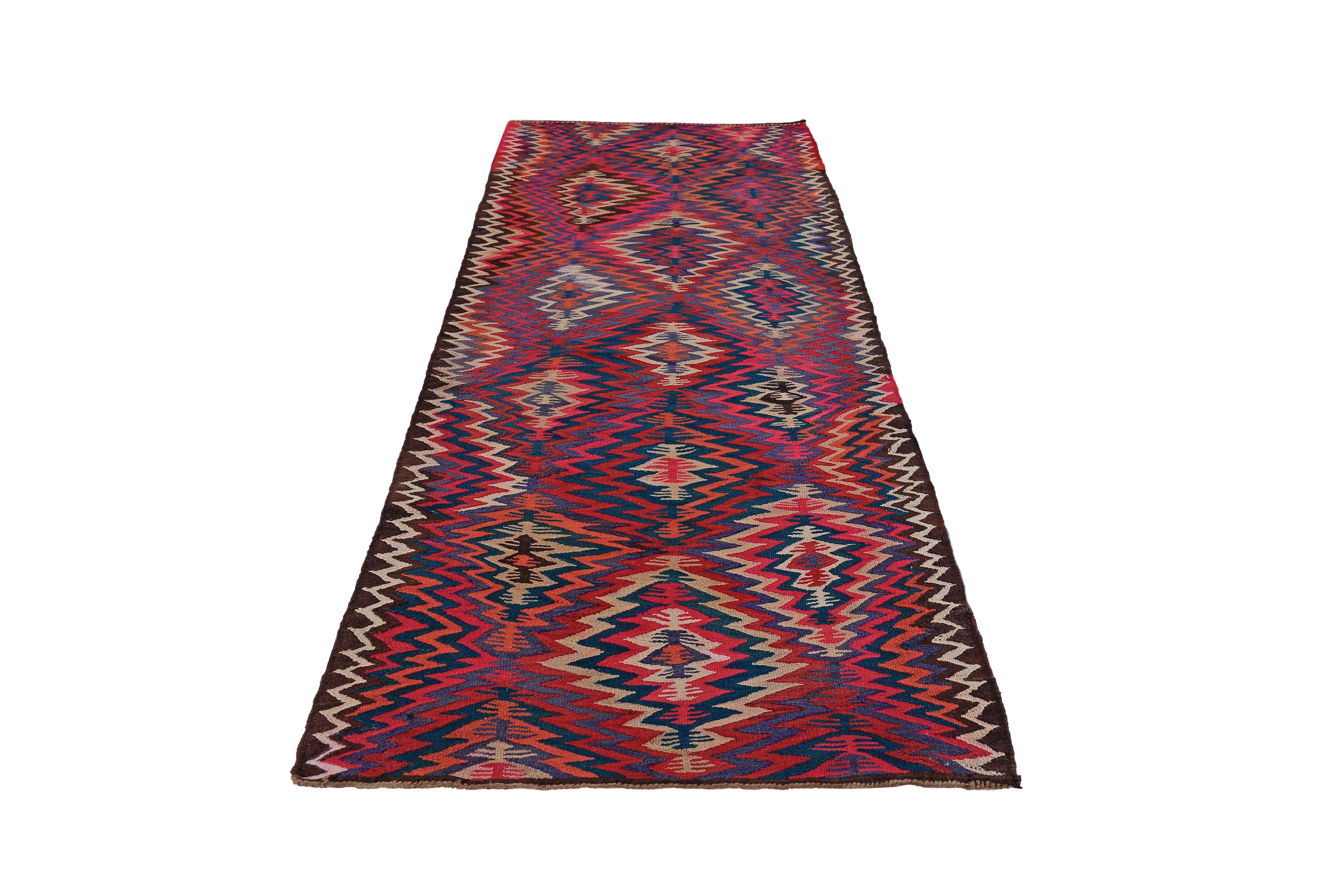 Turkish runner rug handwoven from the finest sheep’s wool and colored with all-natural vegetable dyes that are safe for humans and pets. It’s a traditional Kilim flat-weave design featuring pink, red, and purple tribal details. It’s a stunning piece