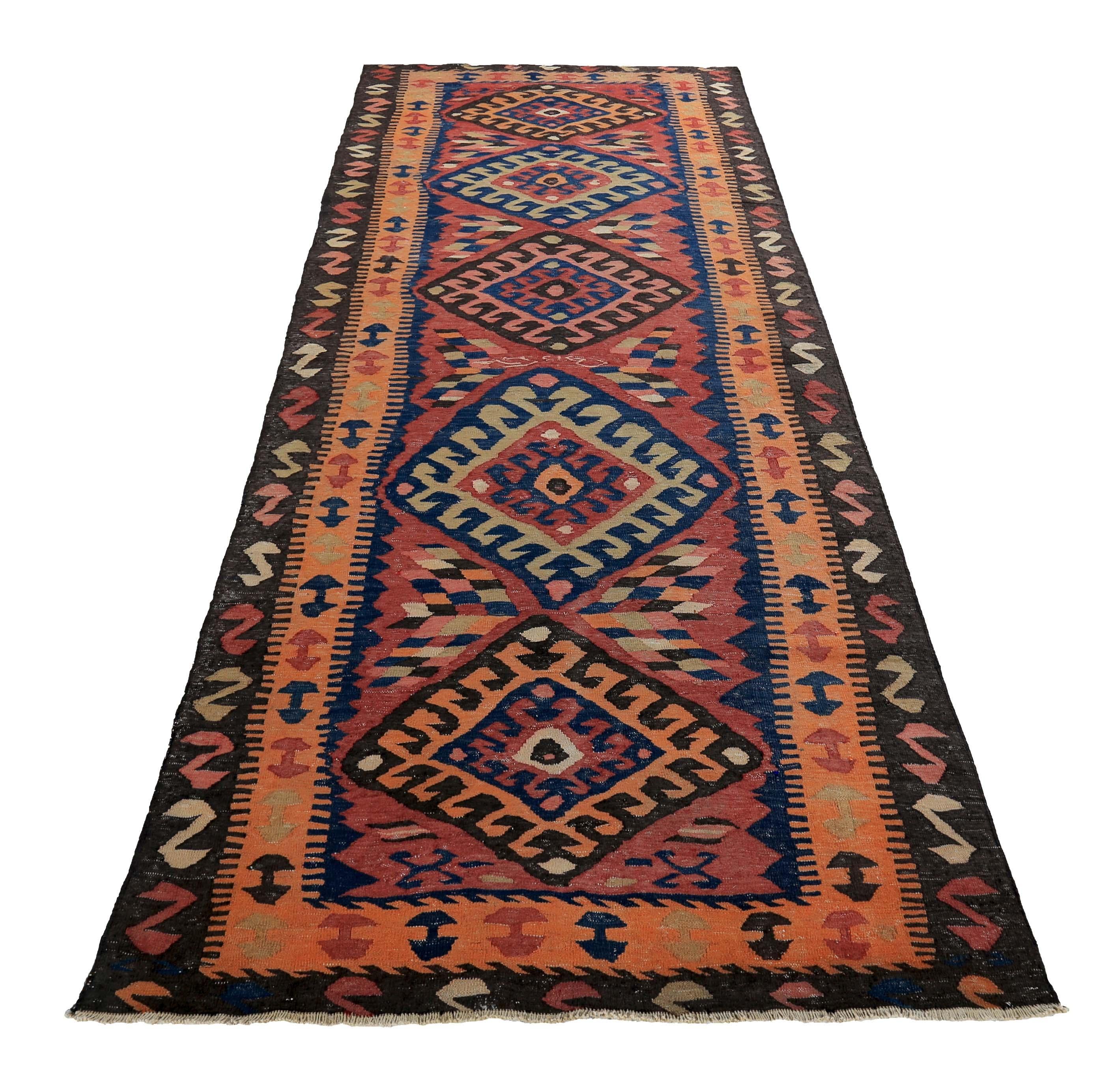 Turkish runner rug handwoven from the finest sheep’s wool and colored with all-natural vegetable dyes that are safe for humans and pets. It’s a traditional Kilim flat-weave design featuring red, blue, and orange tribal details. It’s a stunning piece