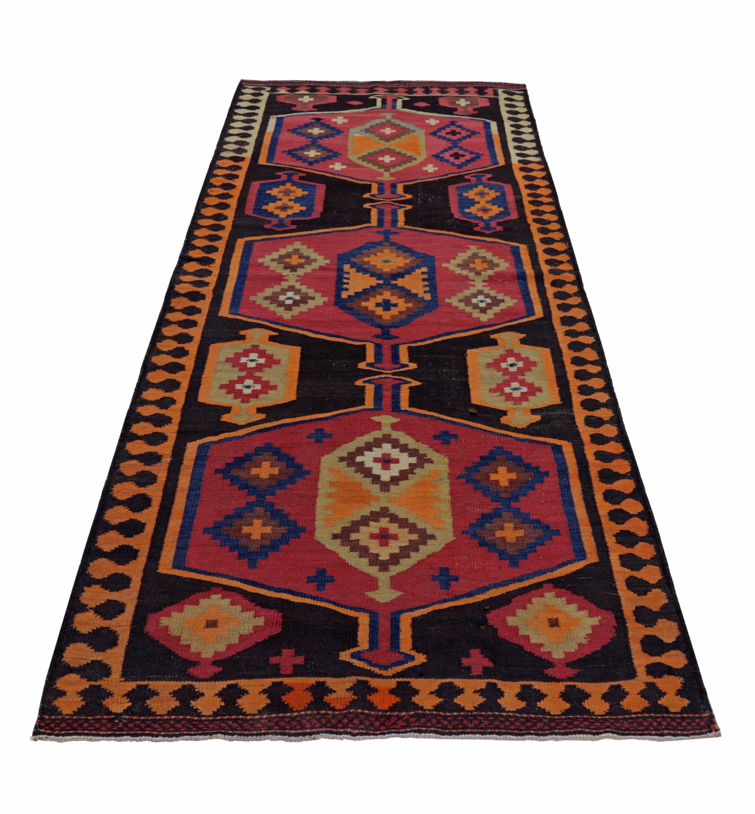 Turkish runner rug handwoven from the finest sheep’s wool and colored with all-natural vegetable dyes that are safe for humans and pets. It’s a traditional Kilim flat-weave design featuring red, orange, and black tribal details. It’s a stunning