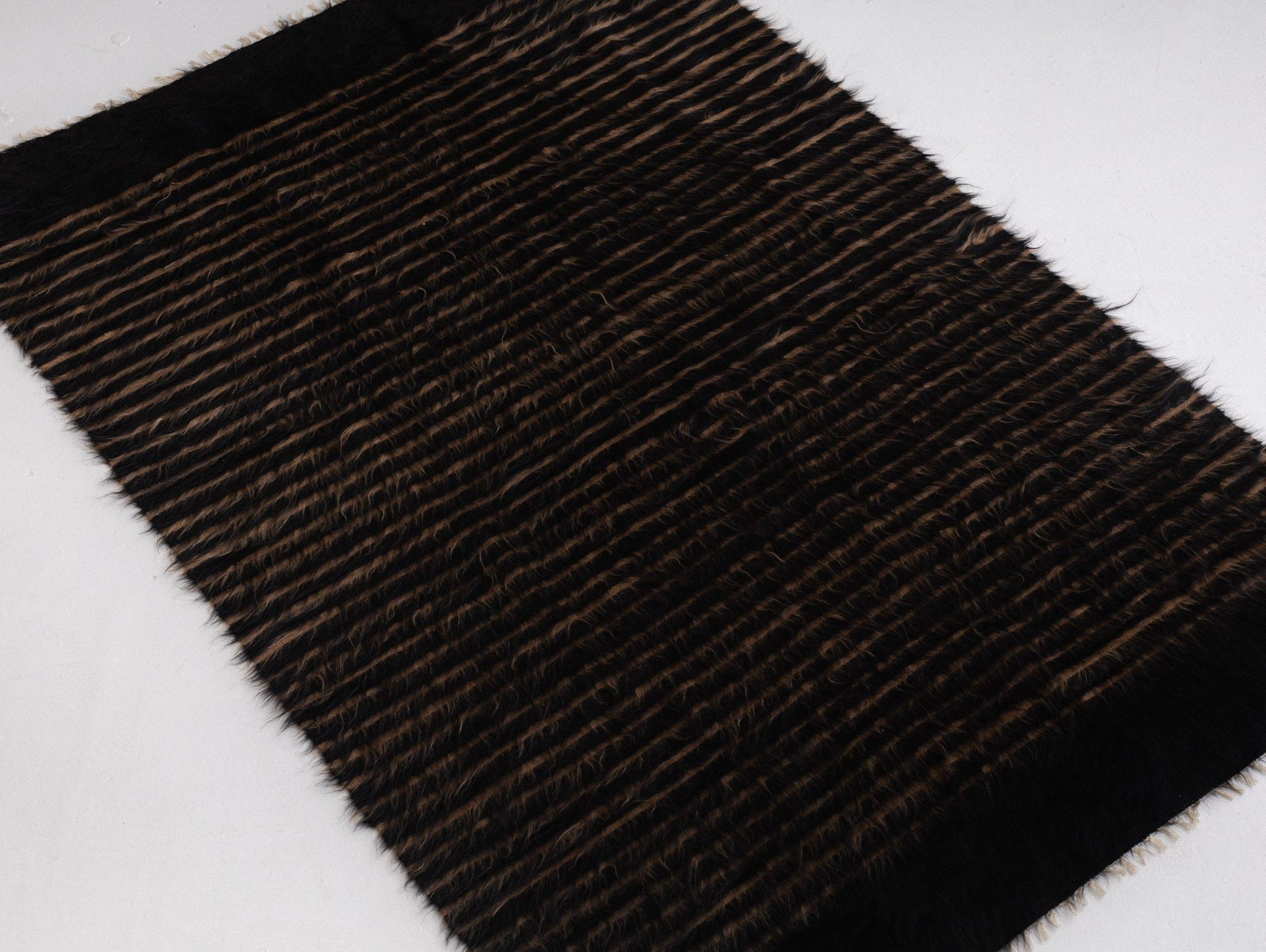 A hand woven Turkish “Siirt” blanket. Made with without dyes from natural color mohair goat wool. A thin flat weave with long shaggy fibers give this weaving its unique fuzzy appearance.
