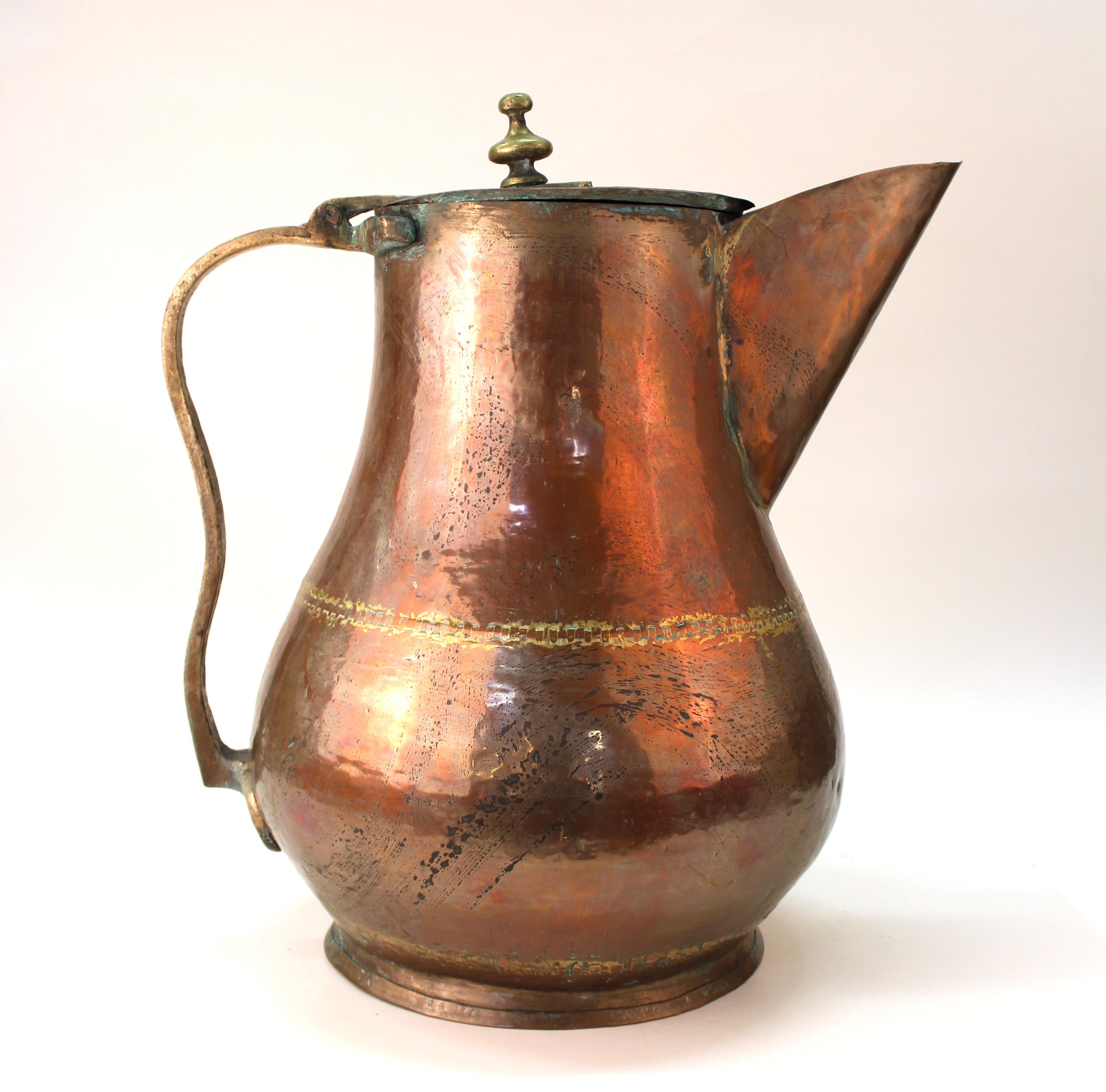 Turkish monumental sized decorative pitcher made in hammered copper with brass accents and handle. The piece does not have an egress for liquid to run into the spout as it is for decorative purposes only. In great vintage condition with