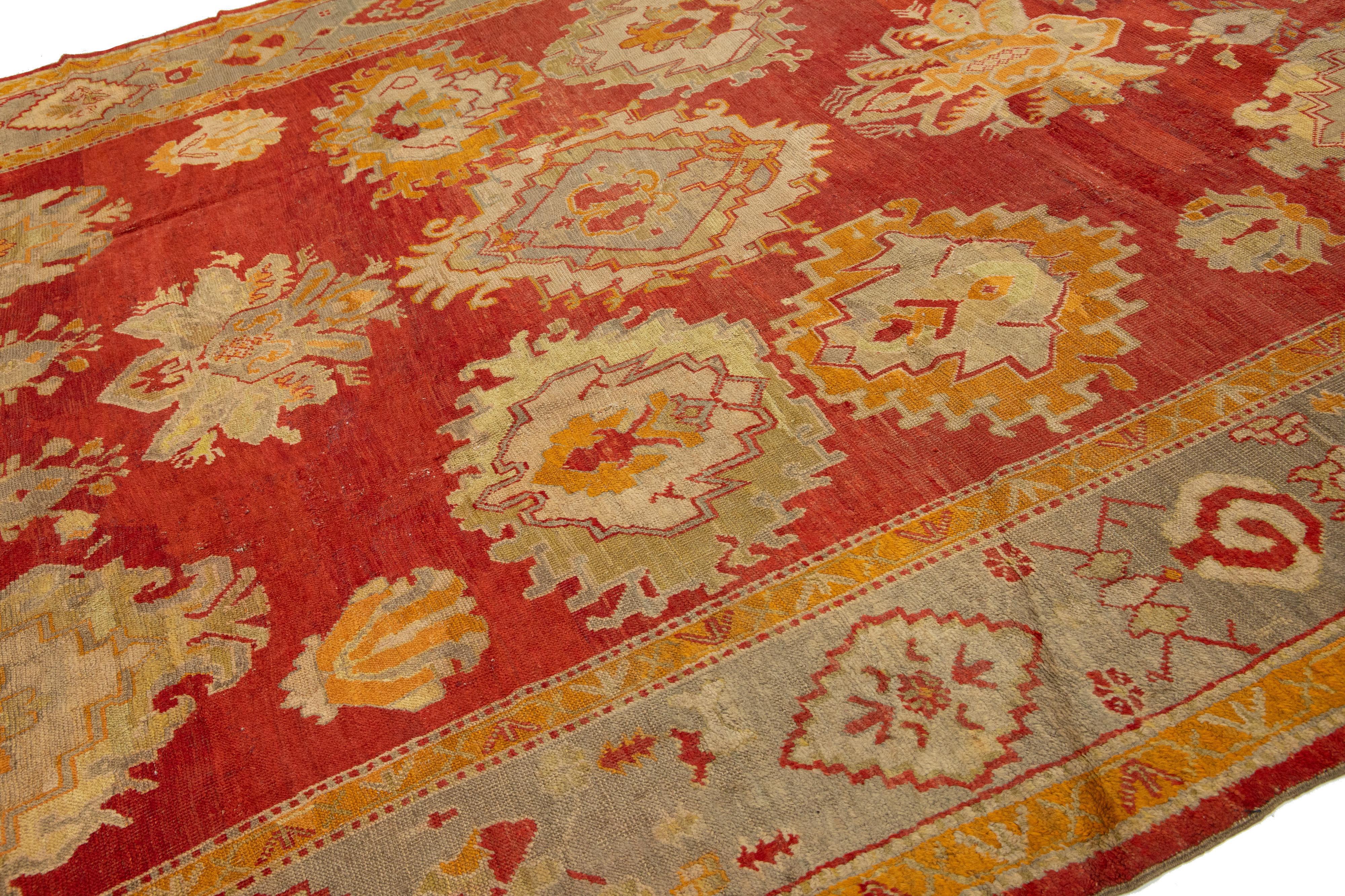 19th Century Turkish Oushak Antique Wool Rug Handmade In Red Featuring a Floral Design For Sale
