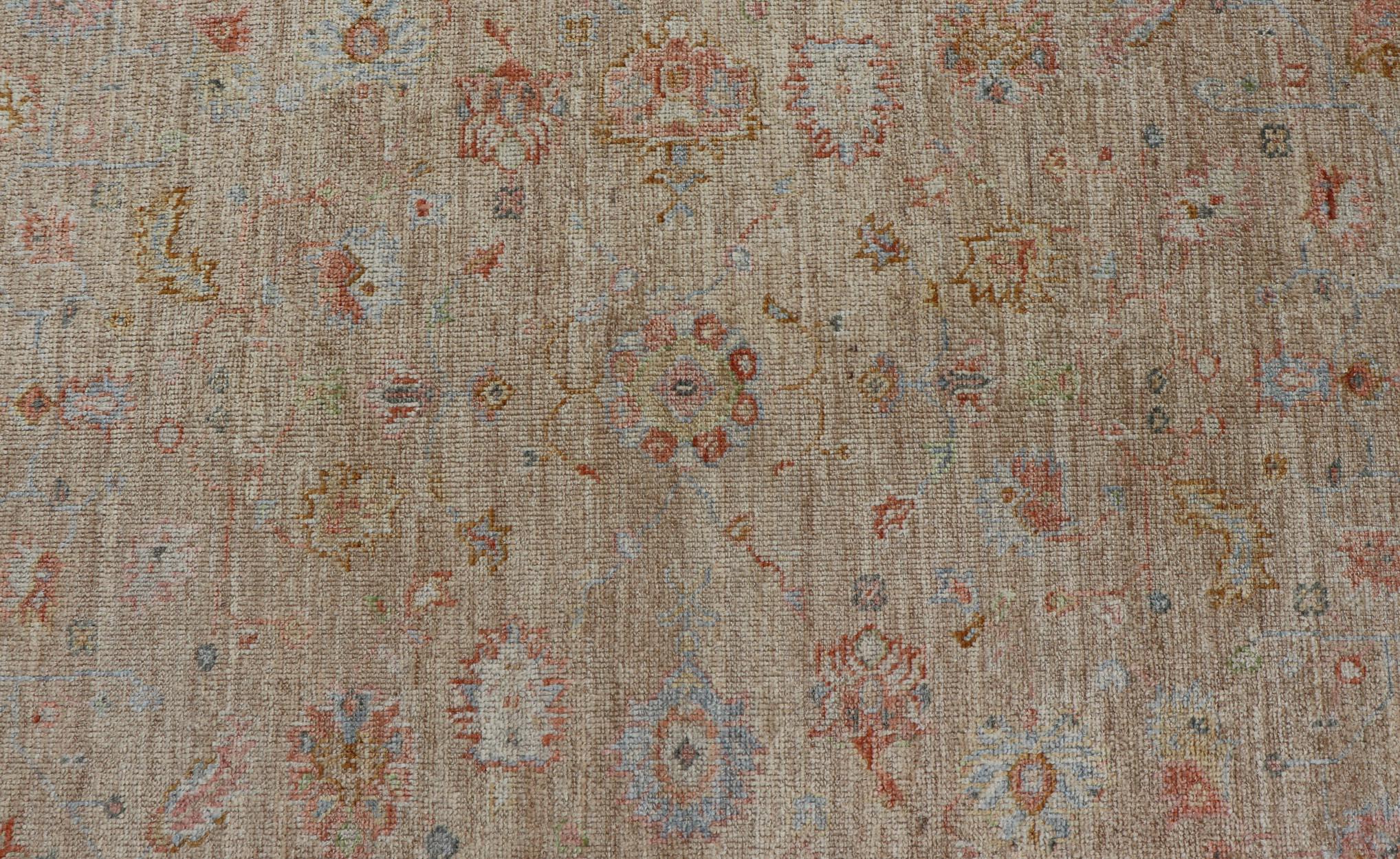 This hand-knotted Oushak has a sub-floral Oushak design that spreads on the the field, rendered in coral, salmon, light blue, gold, and green. The background of the field is a sandy taupe, where as the border is in a cream color. 

 Measures; 5'0