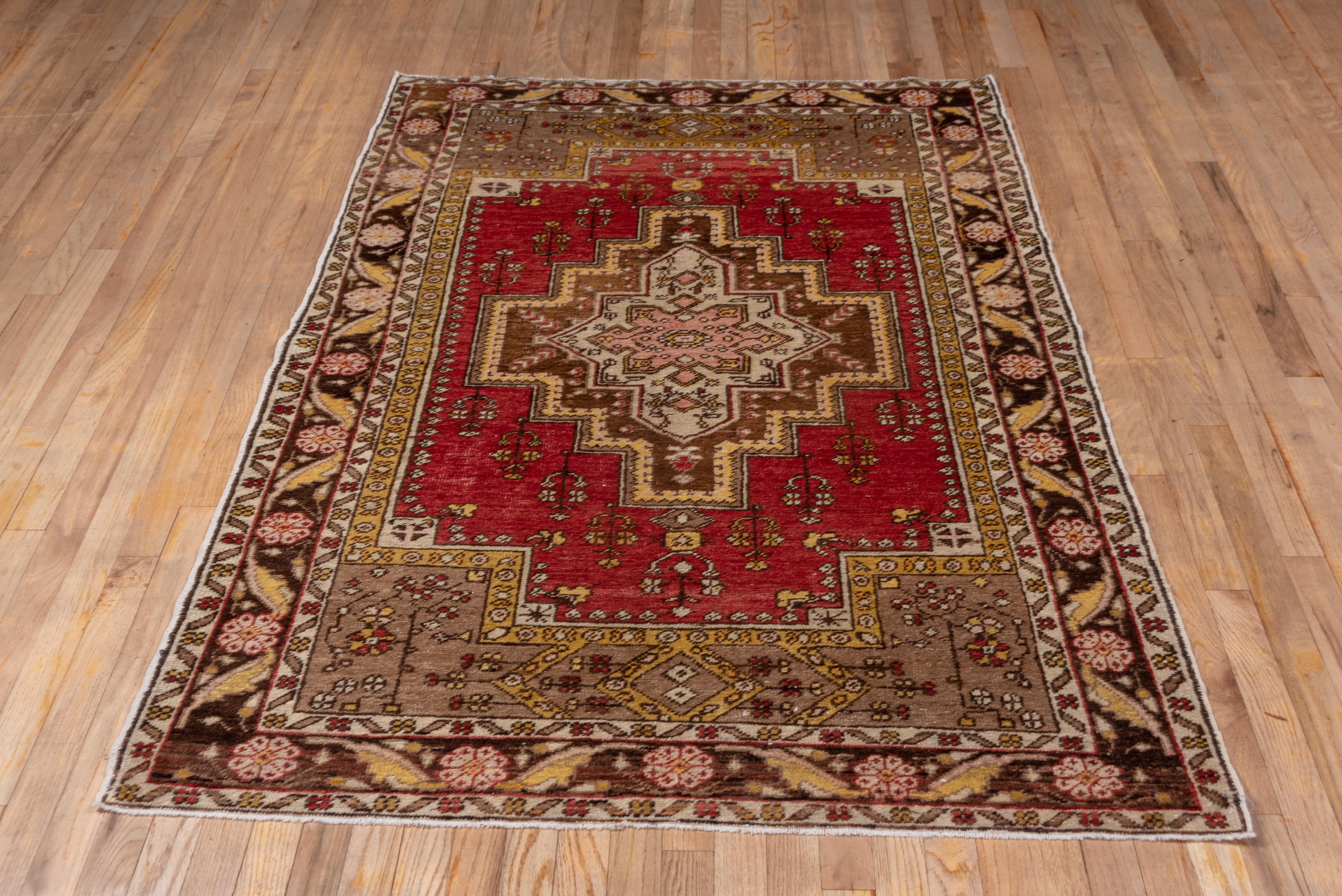 This good condition Turkish village scatter shows a tomato red stepped subfield centered by an ivory octogramme sub-medallion surrounded by an ivory stepped square-ended surround. The green spandrels show rosette flowers and the abrashed brick