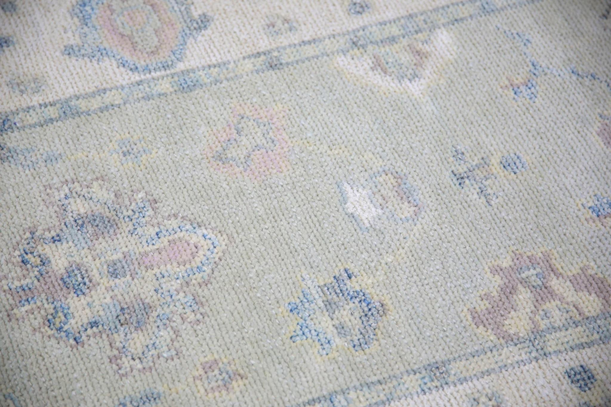 This modern Turkish Oushak rug is a stunning piece of art that has been handwoven using traditional techniques by skilled artisans. The rug features intricate patterns and a soft color palette that is achieved through the use of natural vegetable