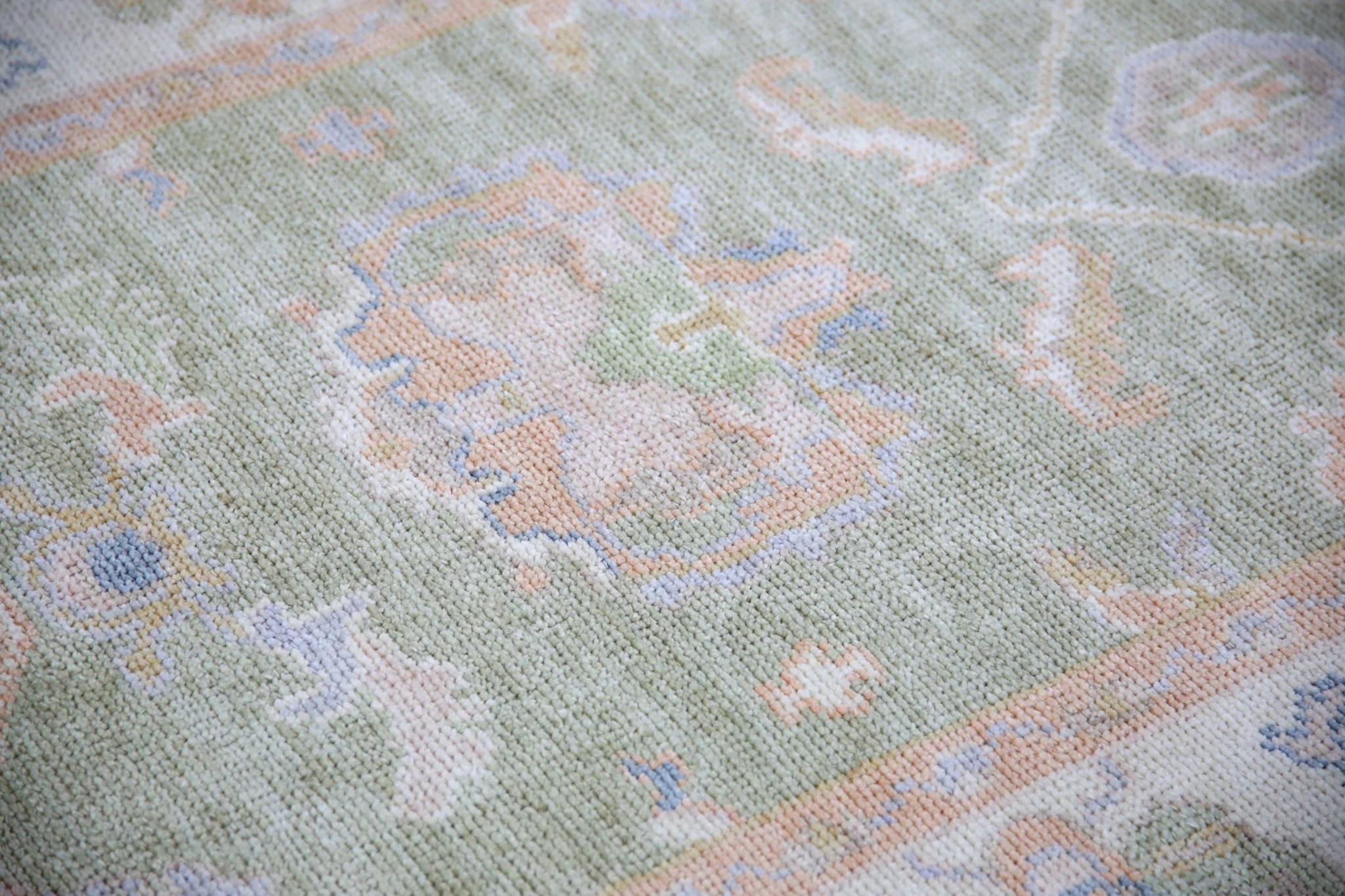 Dieser moderne türkische Oushak-Teppich ist ein atemberaubendes Kunstwerk, das von erfahrenen Kunsthandwerkern mit traditionellen Techniken handgewebt wurde. Der Teppich weist komplizierte Muster und eine weiche Farbpalette auf, die durch die