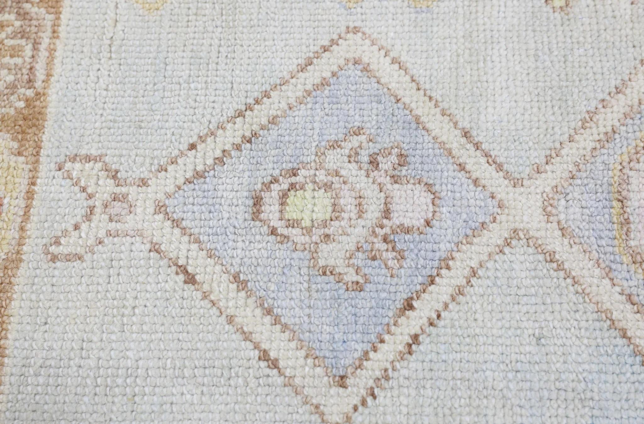 Dieser moderne türkische Oushak-Teppich ist ein atemberaubendes Kunstwerk, das von erfahrenen Kunsthandwerkern mit traditionellen Techniken handgewebt wurde. Der Teppich weist komplizierte Muster und eine weiche Farbpalette auf, die durch die