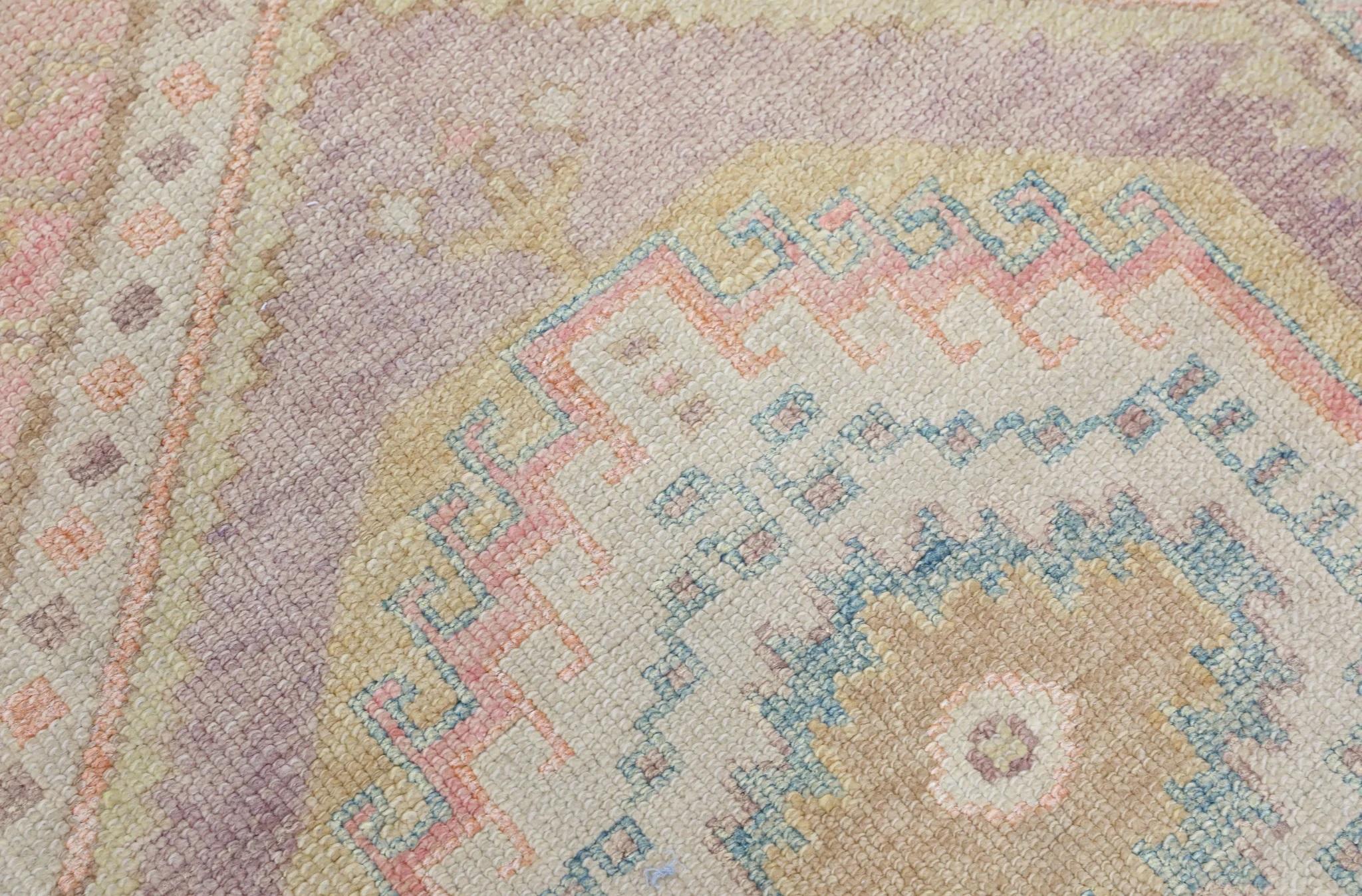 Dieser moderne türkische Oushak-Teppich ist ein atemberaubendes Kunstwerk, das von erfahrenen Kunsthandwerkern mit traditionellen Techniken handgewebt wurde. Der Teppich weist komplizierte Muster und eine weiche Farbpalette auf, die durch die