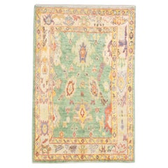 Alfombra turca Oushak verde tejida a mano en lana con estampado floral de colores 5'4" x 8'