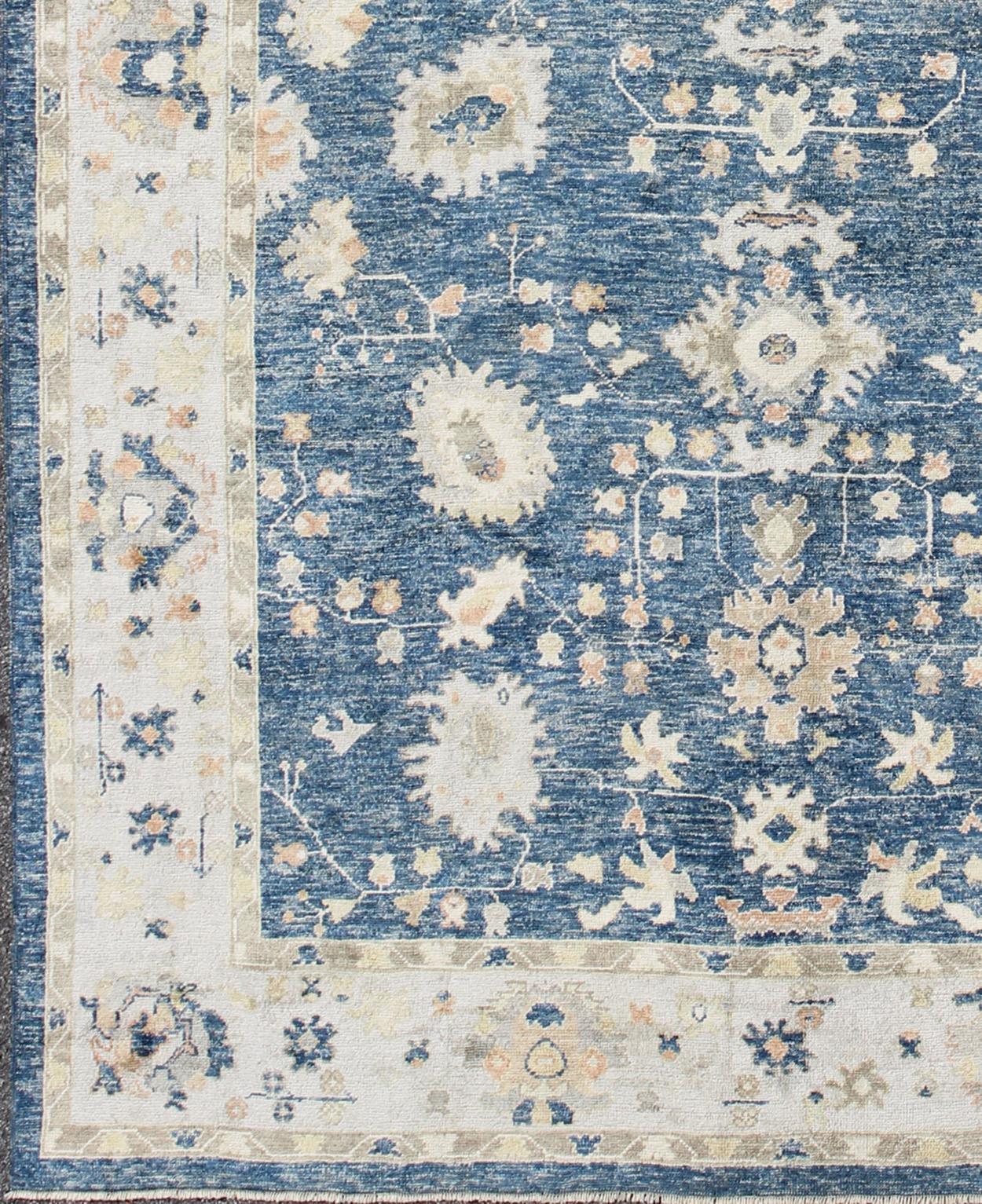 Turkish Oushak rug in blue background with neutral color palette and all-over flower design. Keivan Woven Arts / rug EN-165651, country of origin / type: Turkey / Oushak
Measures: 10'5 x 13'4.
This traditional Oushak rug from Turkey features a